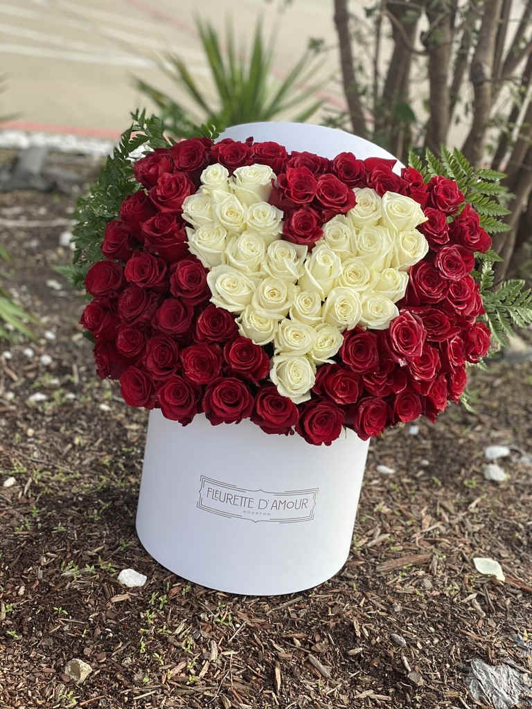 Heart-shaped bouquet of red and white roses in a white box