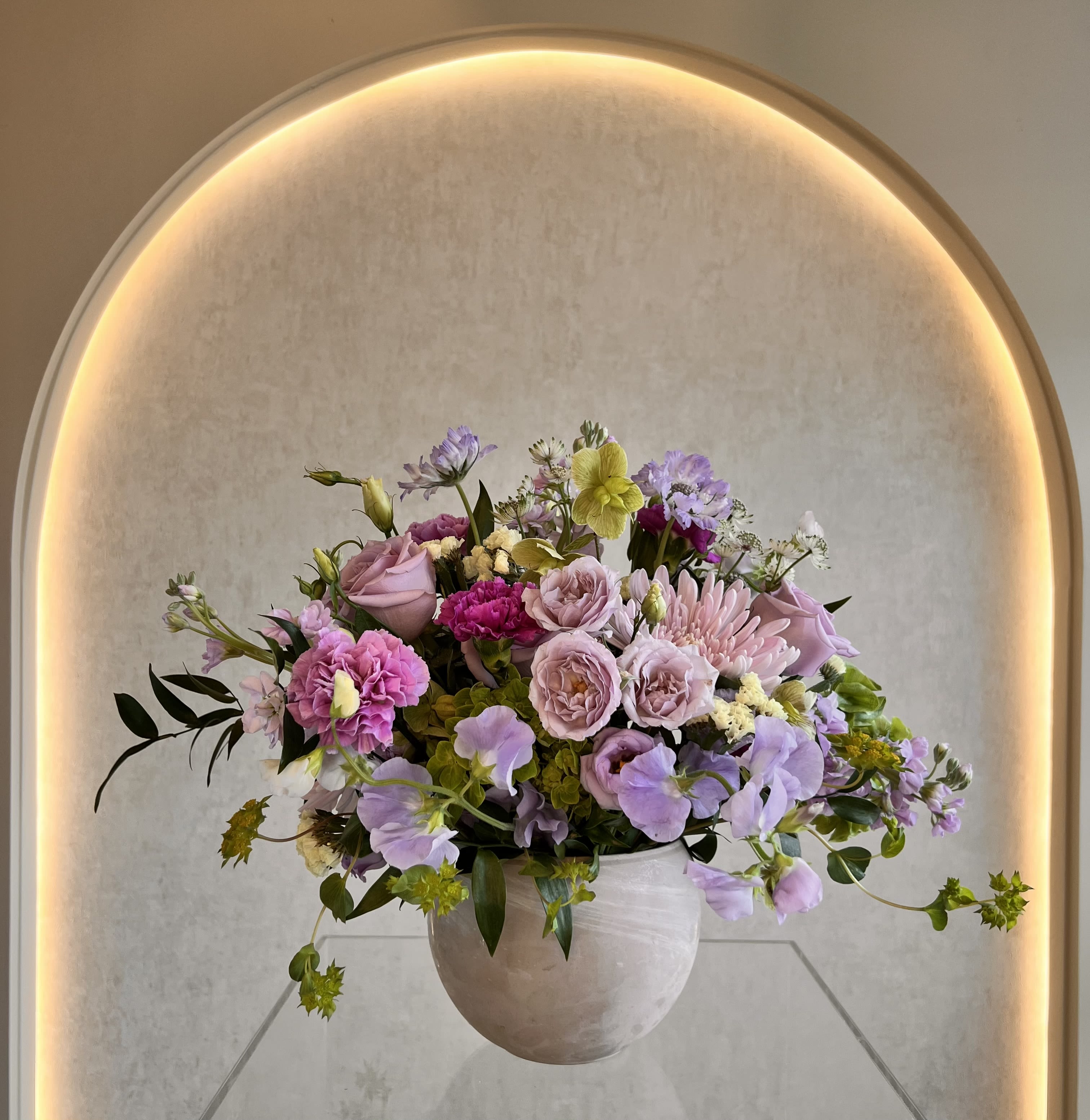 Lavender Fields  - Full rounded mix of roses, carnations, lisianthus in pink, lavender and white in a ceramic vase.