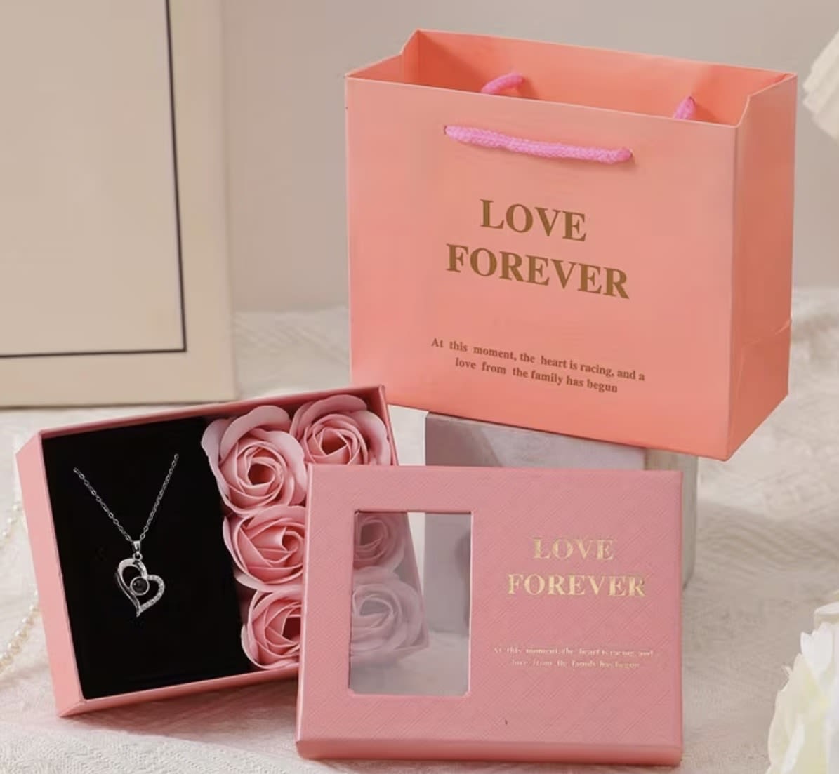 Pink gift boxes with faux roses and a heart necklace