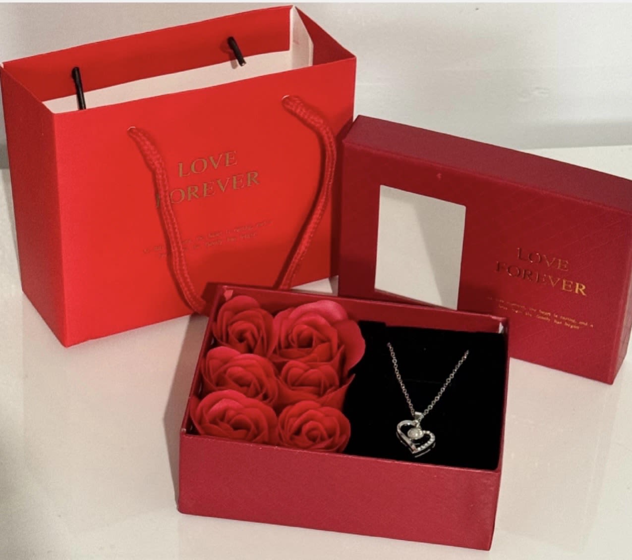 Red gift box with rose-shaped soap flowers and a heart necklace