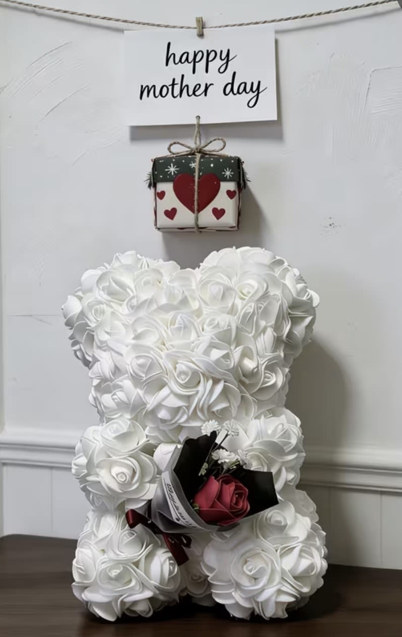 White teddy bear with a small rose bouquet and a "happy mother day" sign