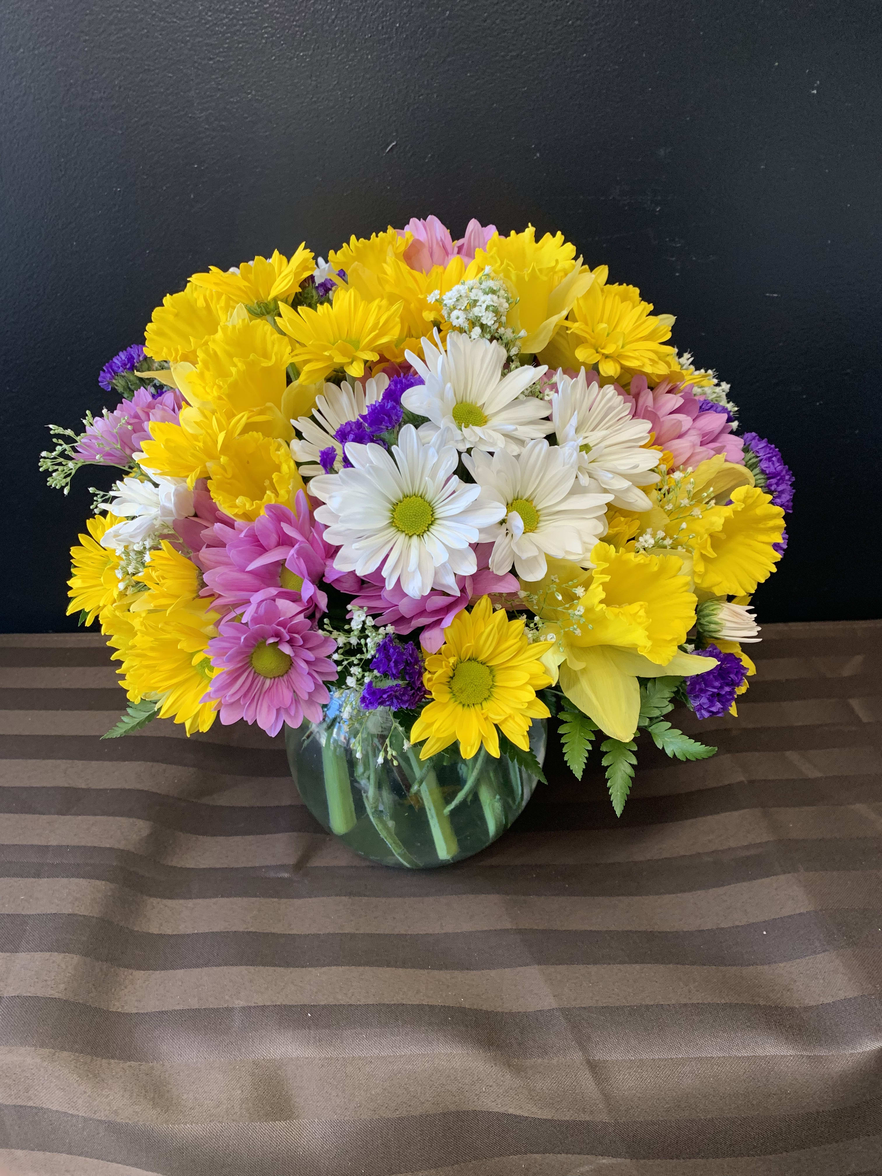 Mixed bouquet of daisies and chrysanthemums in a glass vase
