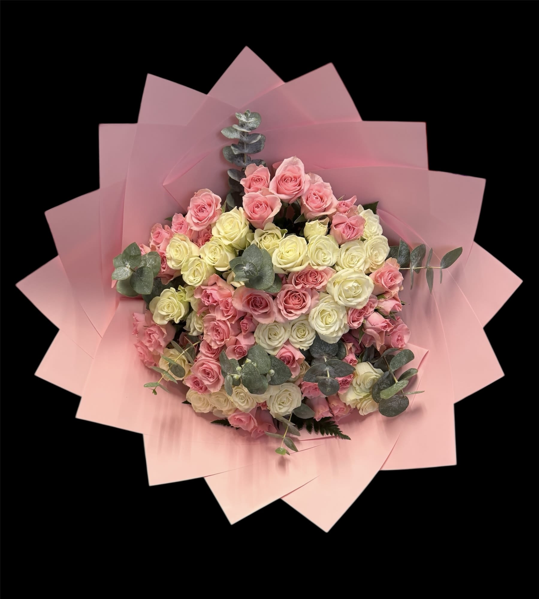 Bouquet of pink and cream roses wrapped in pink paper