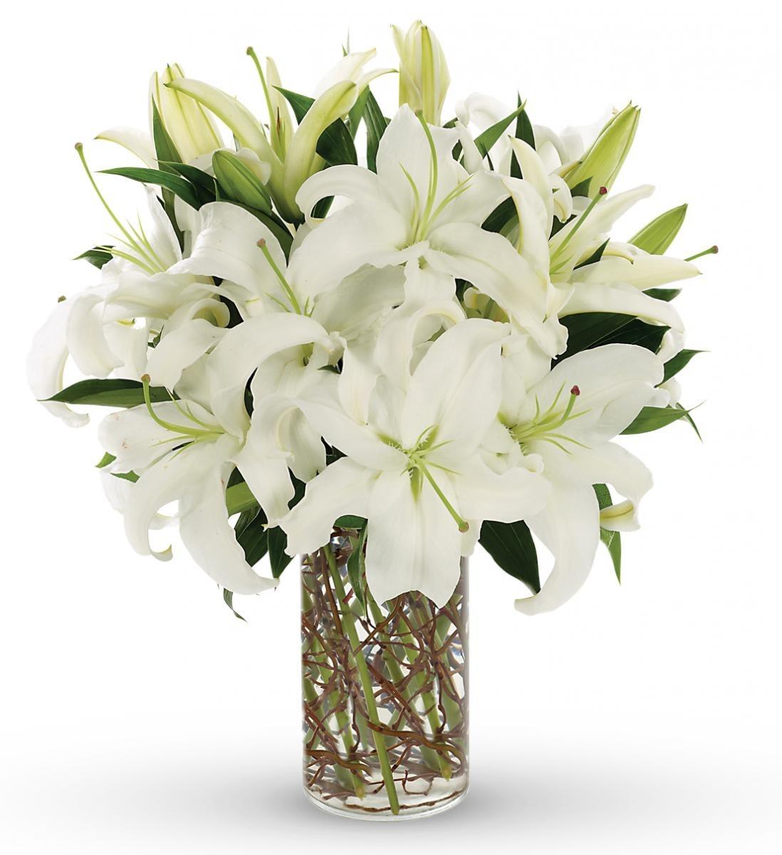 White lilies arranged in a clear glass vase