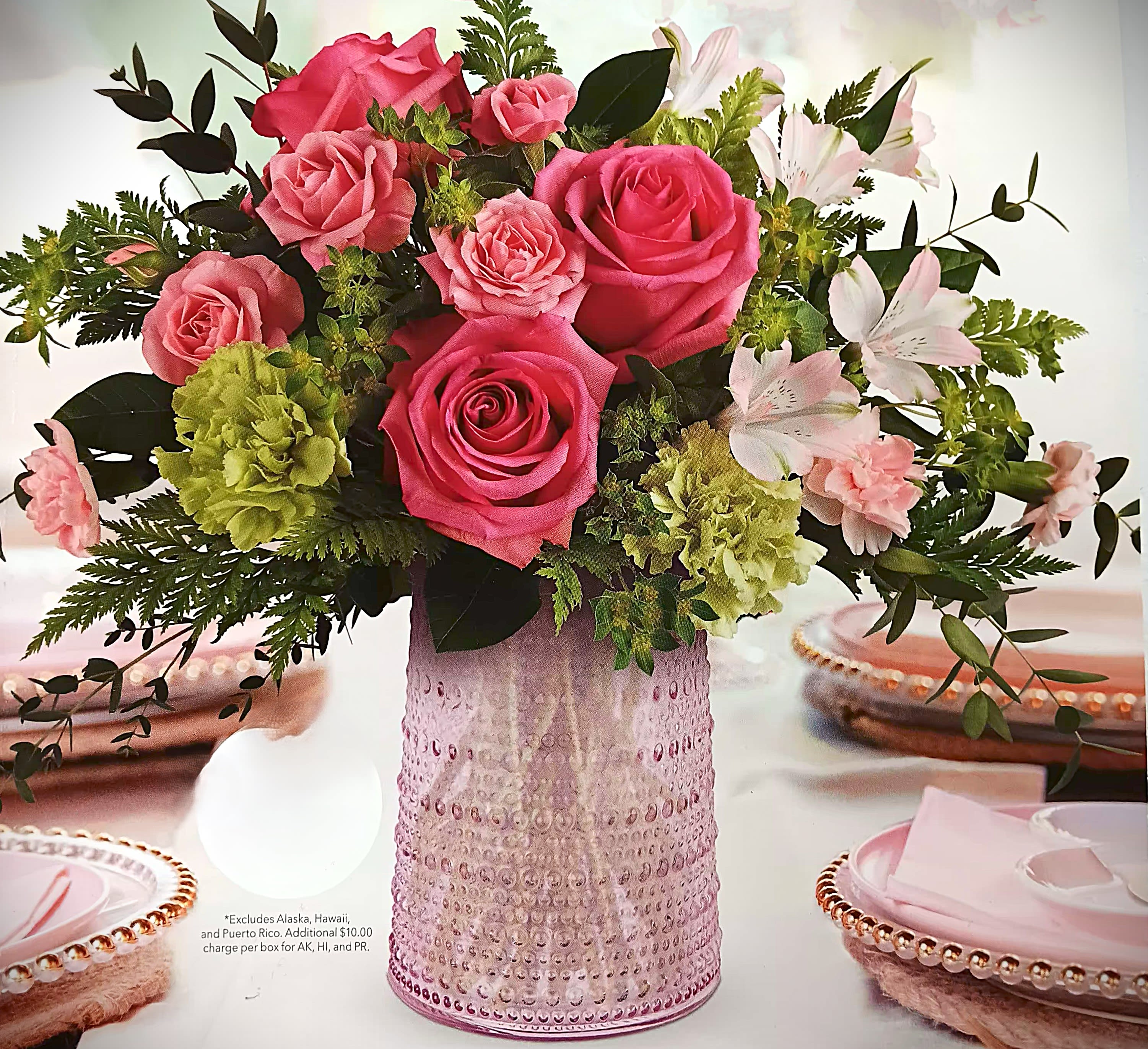 Pink roses and pale flowers arranged in a textured pink vase