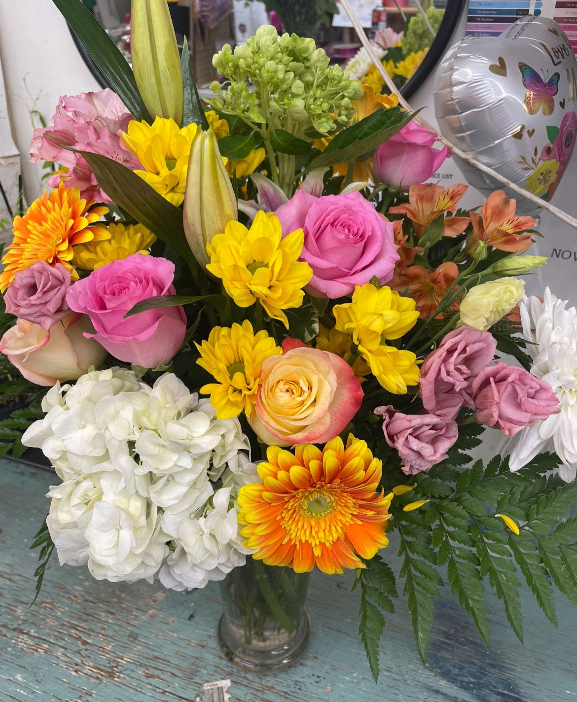 Florally Yours by Lotherington's - Bright pink roses and lilies come together with gerbera daisies, lisianthus and greenery for this large arrangement. Styled in a natural shape, this arrangement would impress anybody.    APPROXIMATE DIMENSIONS 22" W X 24" H  ***Colors and blooms maybe substituted depending on season and availability ***