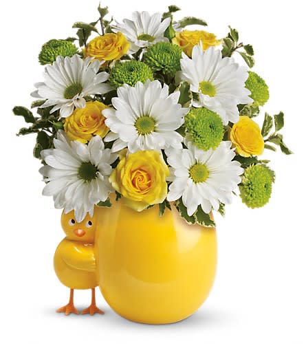 Yellow vase with daisies and roses, plus a small chick figurine