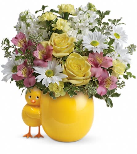 Yellow floral arrangement in a chick-shaped vase with daisies and roses