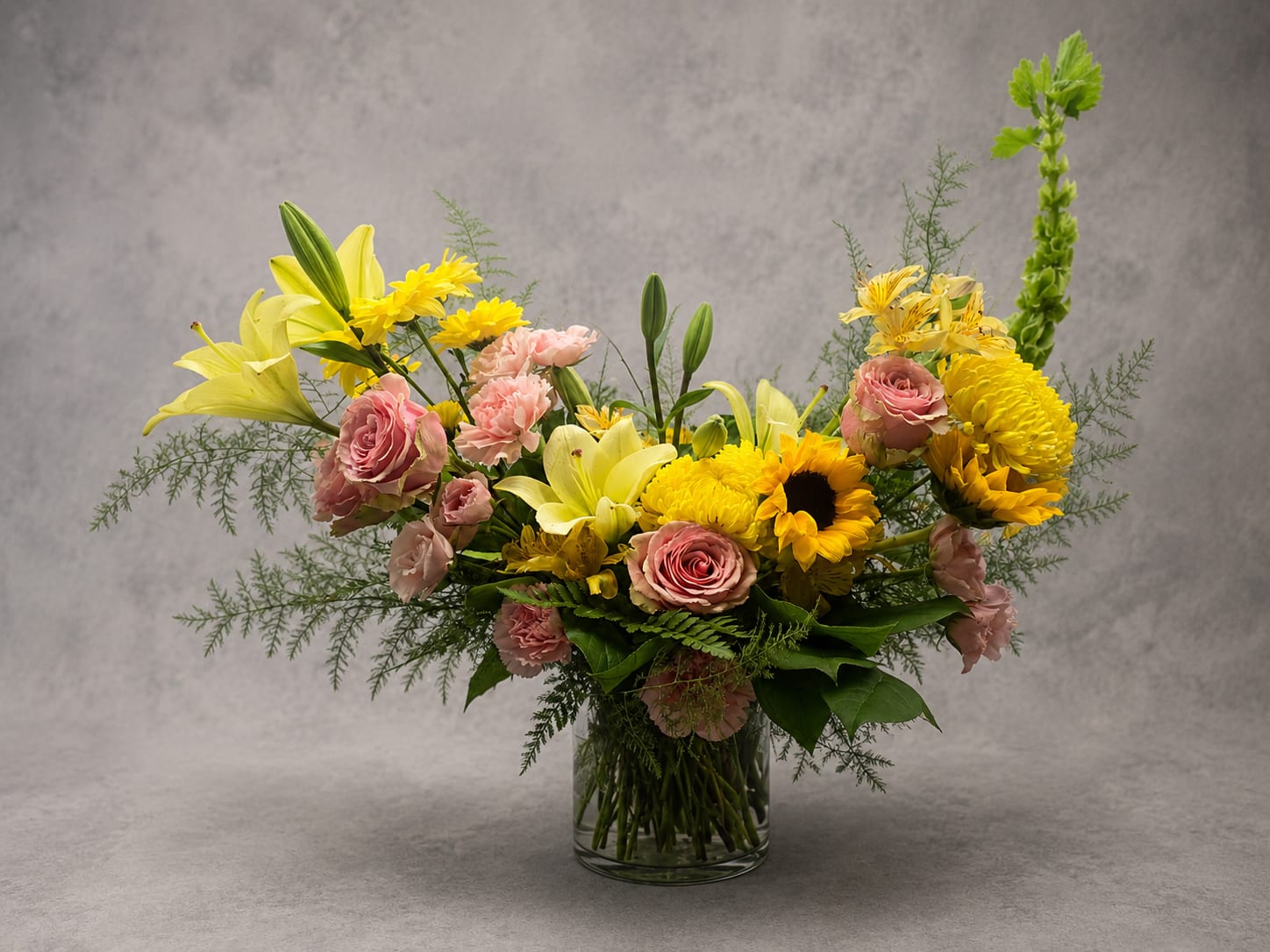 Golden Hour - Inspired by the warmth of a summer sunset, Golden Hour features cheerful sunflowers, soft pink roses, lilies, and seasonal blooms arranged in a lush garden style. Bright, joyful, and full of charm, this design is perfect for celebrating life's happiest moments.