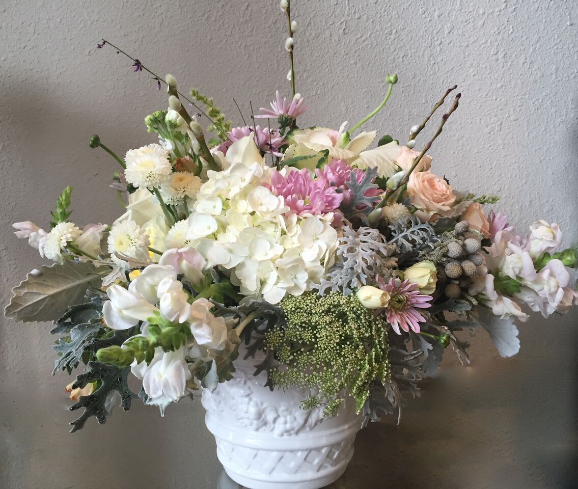 Classic Pastels - Hydrangeas, mums, roses, and other assorted flowers arranged together in an elegant ceramic vessel. This arrangement features an ensemble of beautiful, pastel flowers arranged in a lush design. 