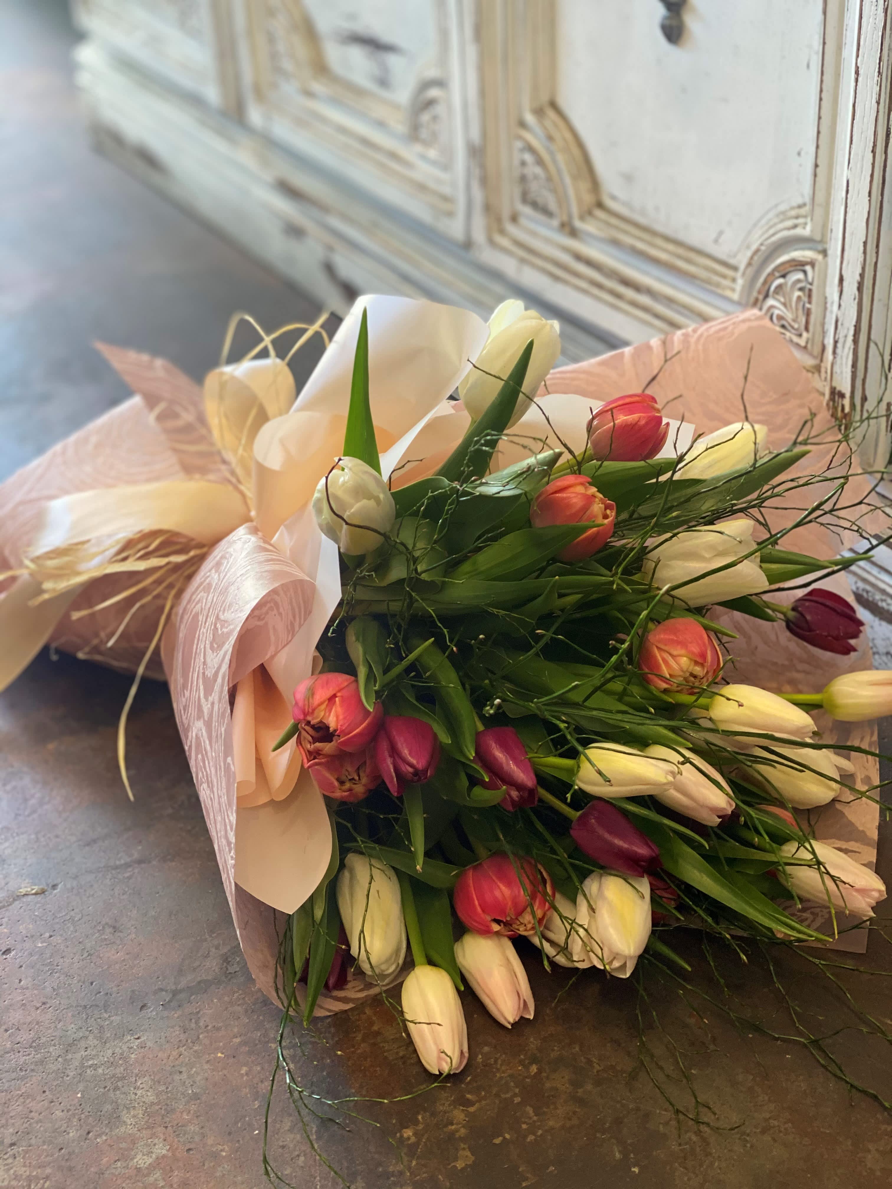 Wrap Me Up Tulips  - A beautiful  handheld bouquet of spring colored tulips  wrapped in pretty papers, grace, and a touch of magic, Please note that this bouquet is a hand-tied arrangement and should be placed in a vase with water immediately. 
