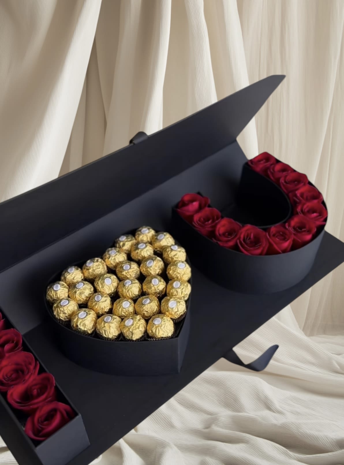 Heart-shaped box of red roses and gold-wrapped chocolates