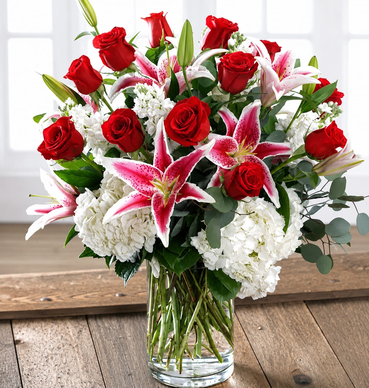 Lovestruck - She will love our combination garden of 12 exclusive Ecuadorian Red Andes Roses and Dutch garden flowers including full-bloom garden hydrangea and fragrant stargazer lilies bursting from a chic glass vase. Approximately 27"H x 19"W