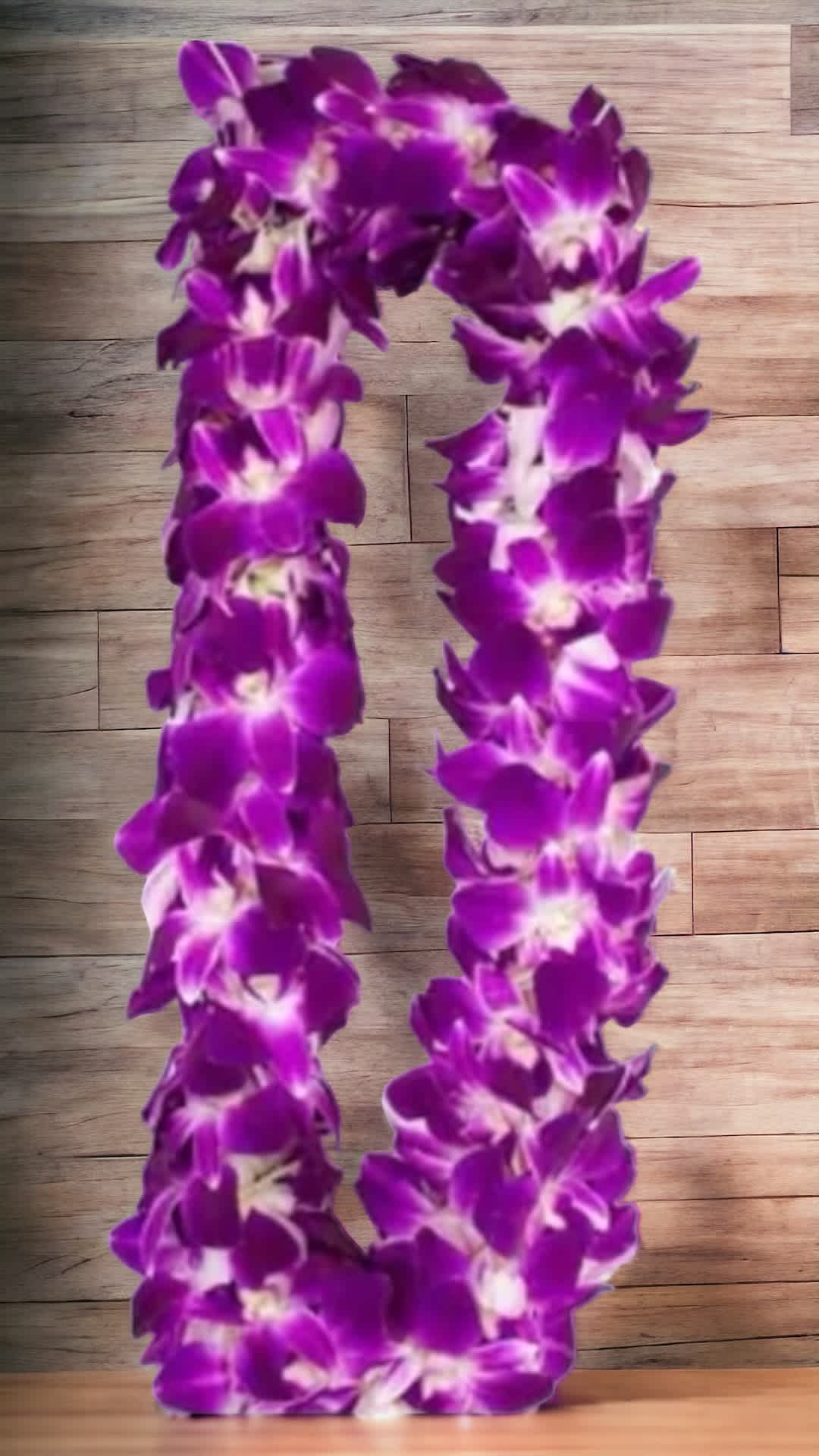Purple orchid lei on a wood surface