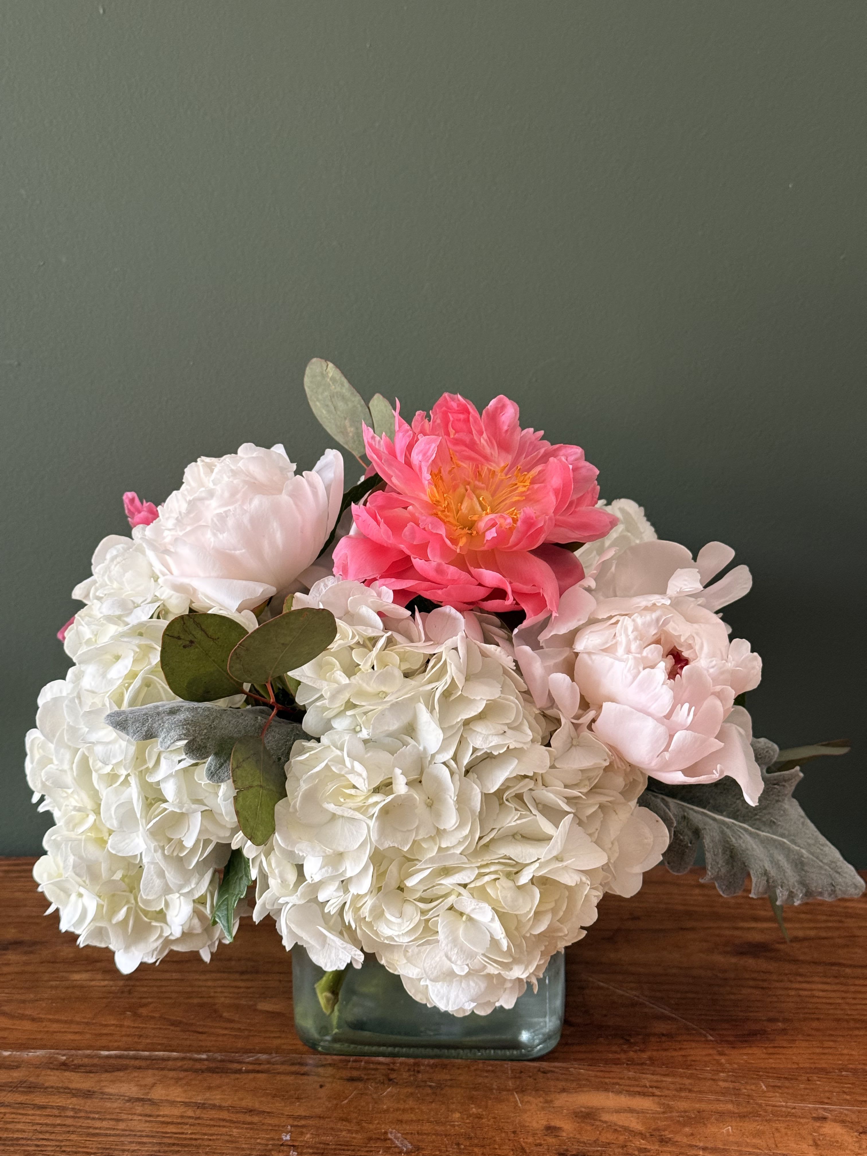 Pink and white peonies with hydrangeas in a glass vase