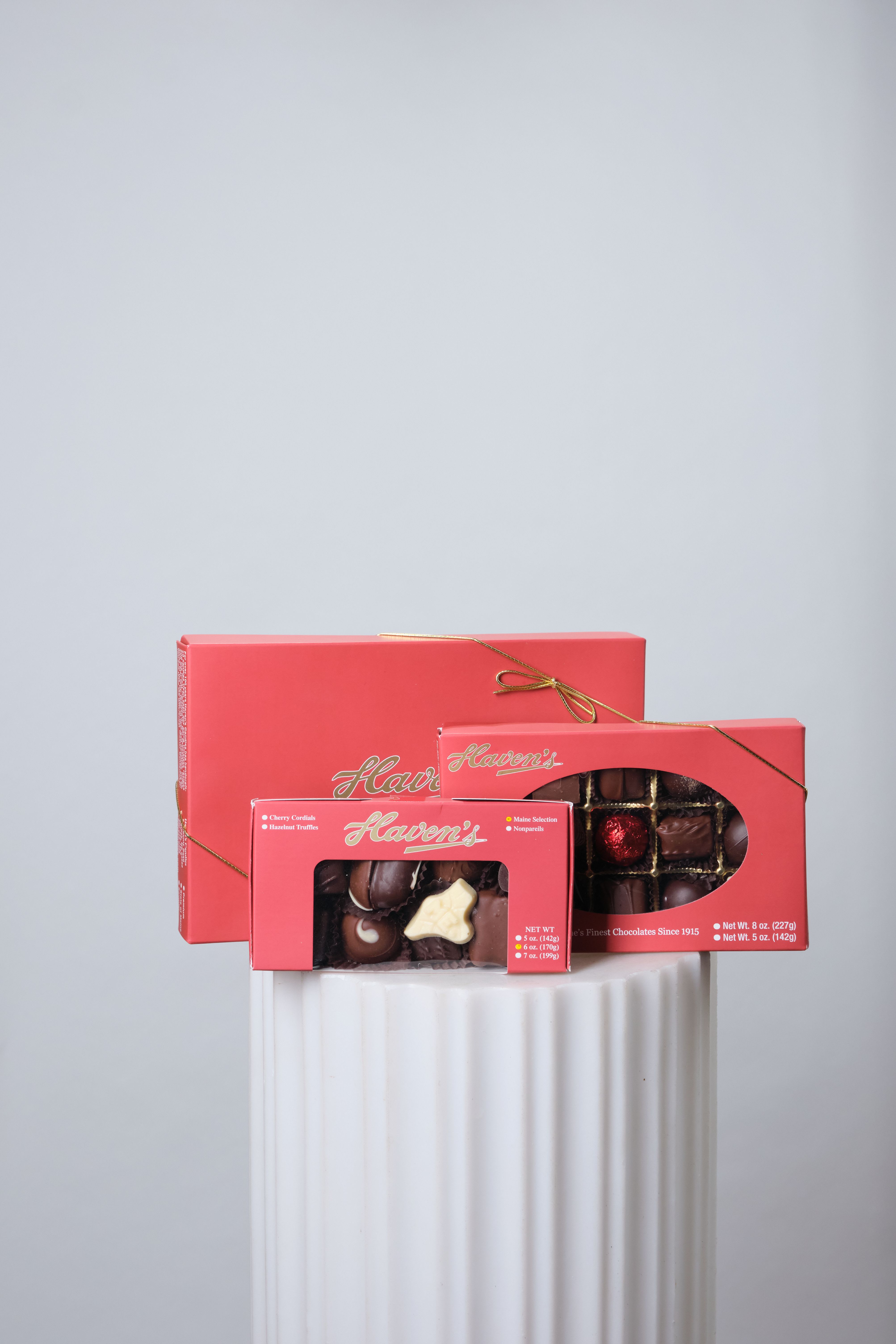 Three boxes of assorted chocolates tied with gold ribbon