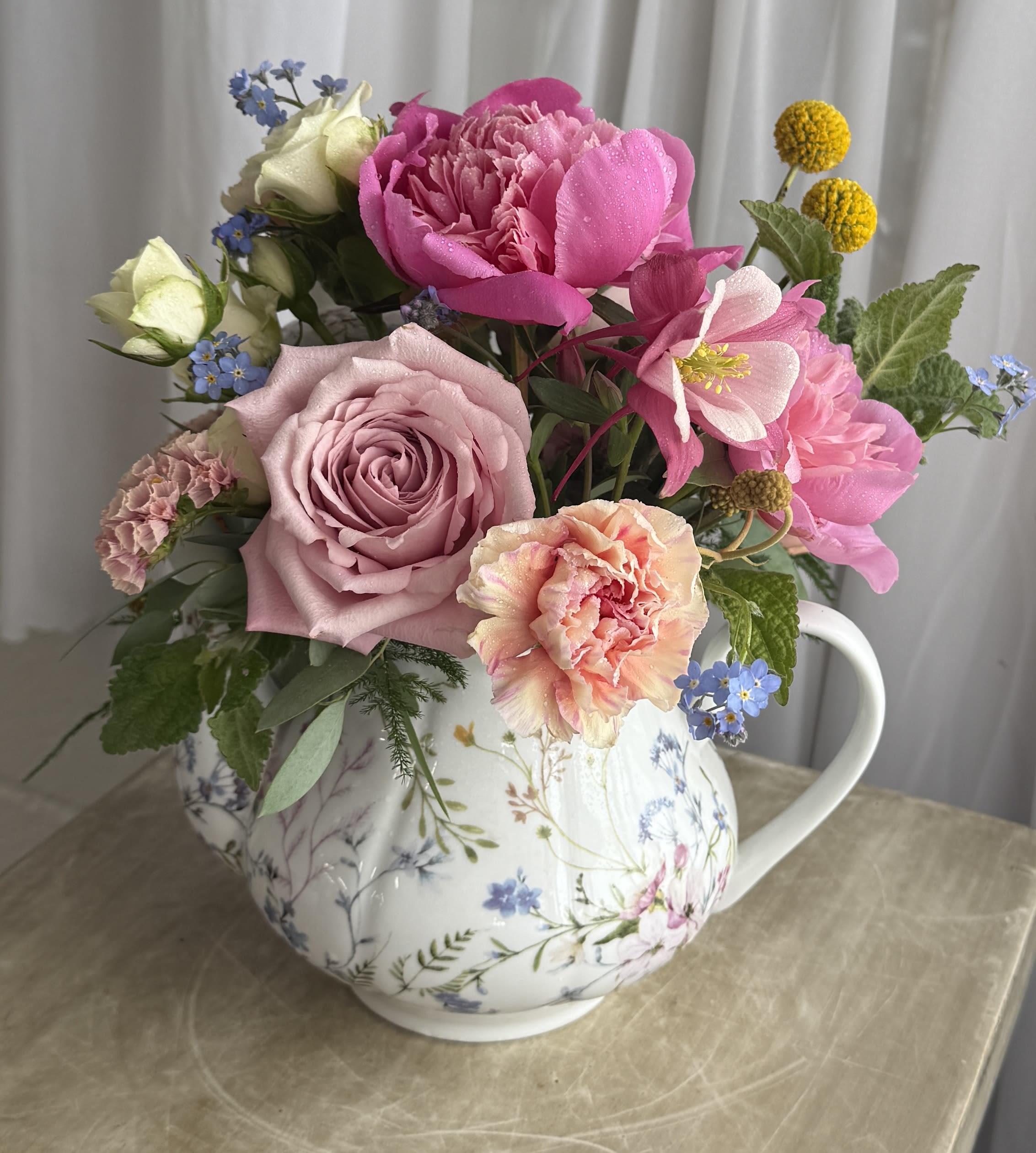 Summer Teapot - A floral teapot filled with corresponding flowers and subtle greenery. Perfect for Mother's Day. As always, substitutions may be made based on what's available. 