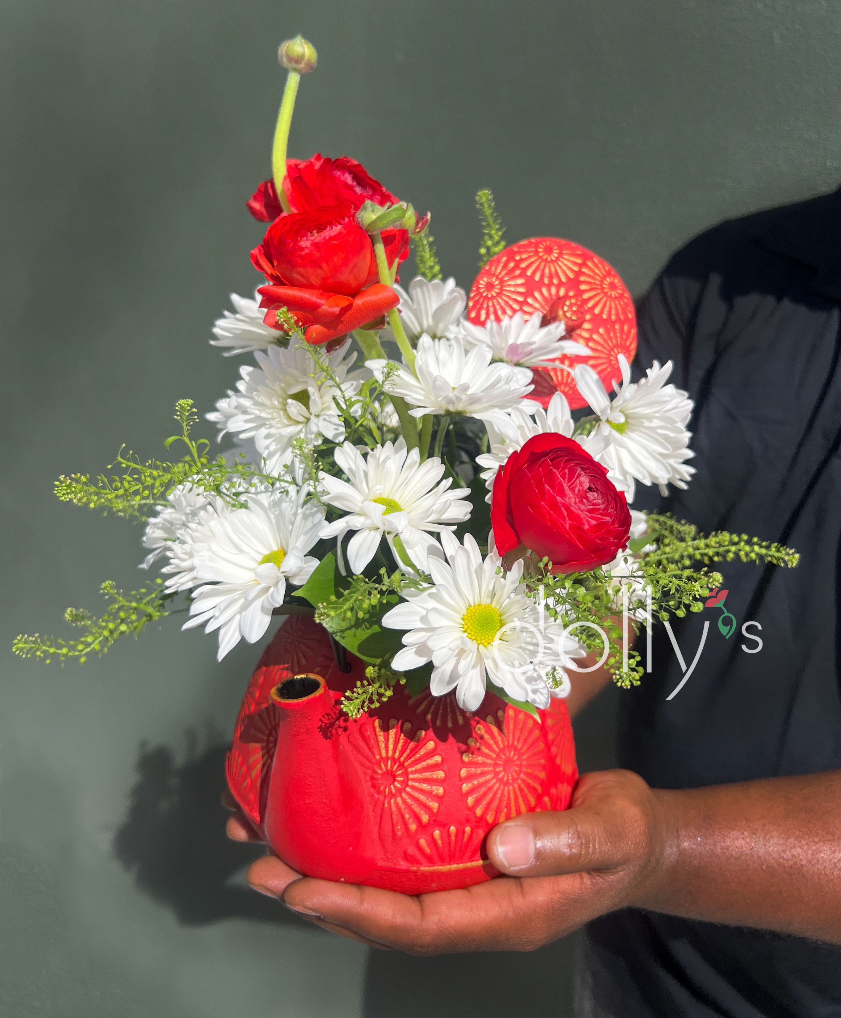 Red and white flower arrangement in a red patterned vase