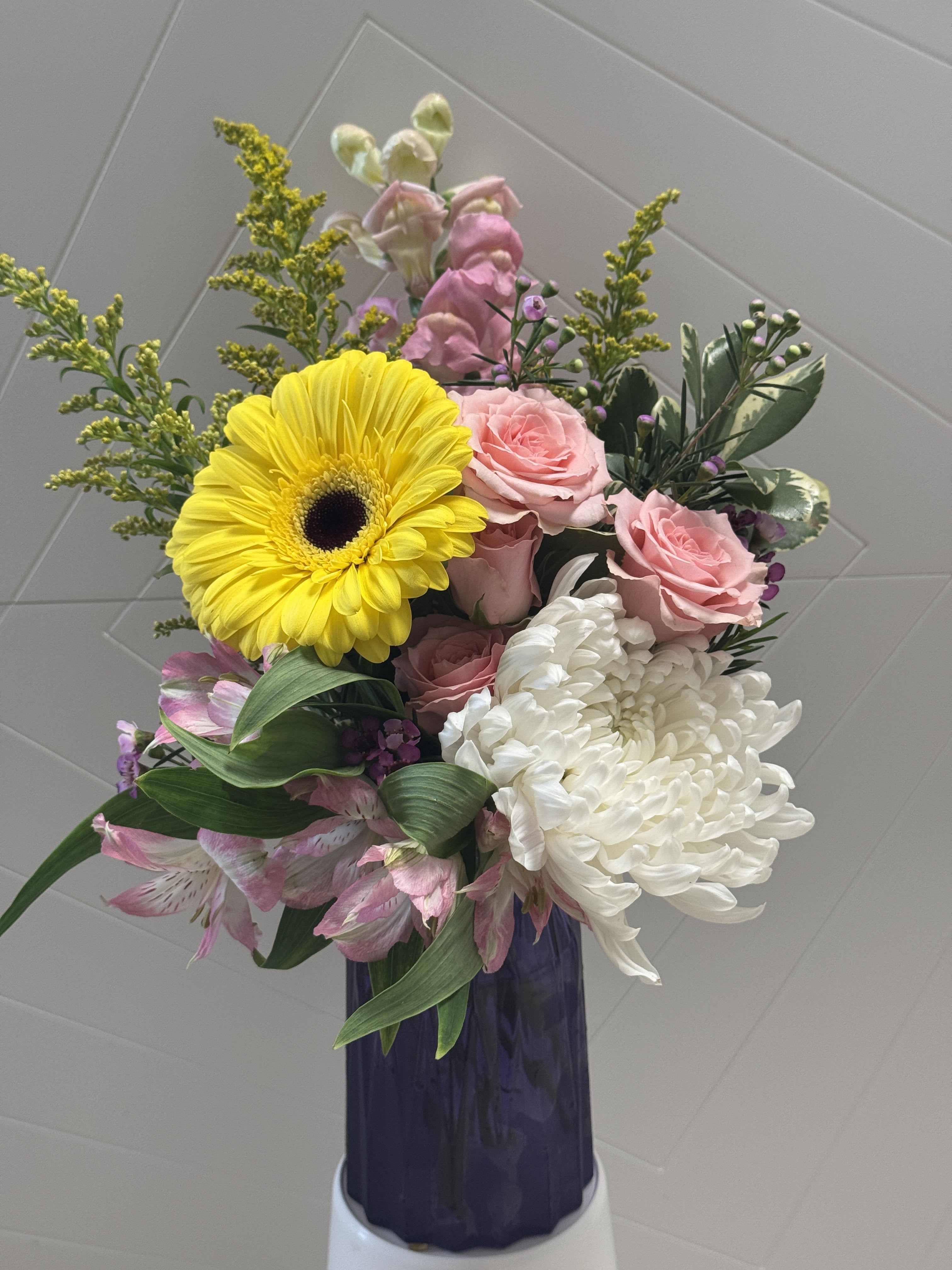 Bouquet of pink roses, white chrysanthemum, and yellow gerbera in a vase