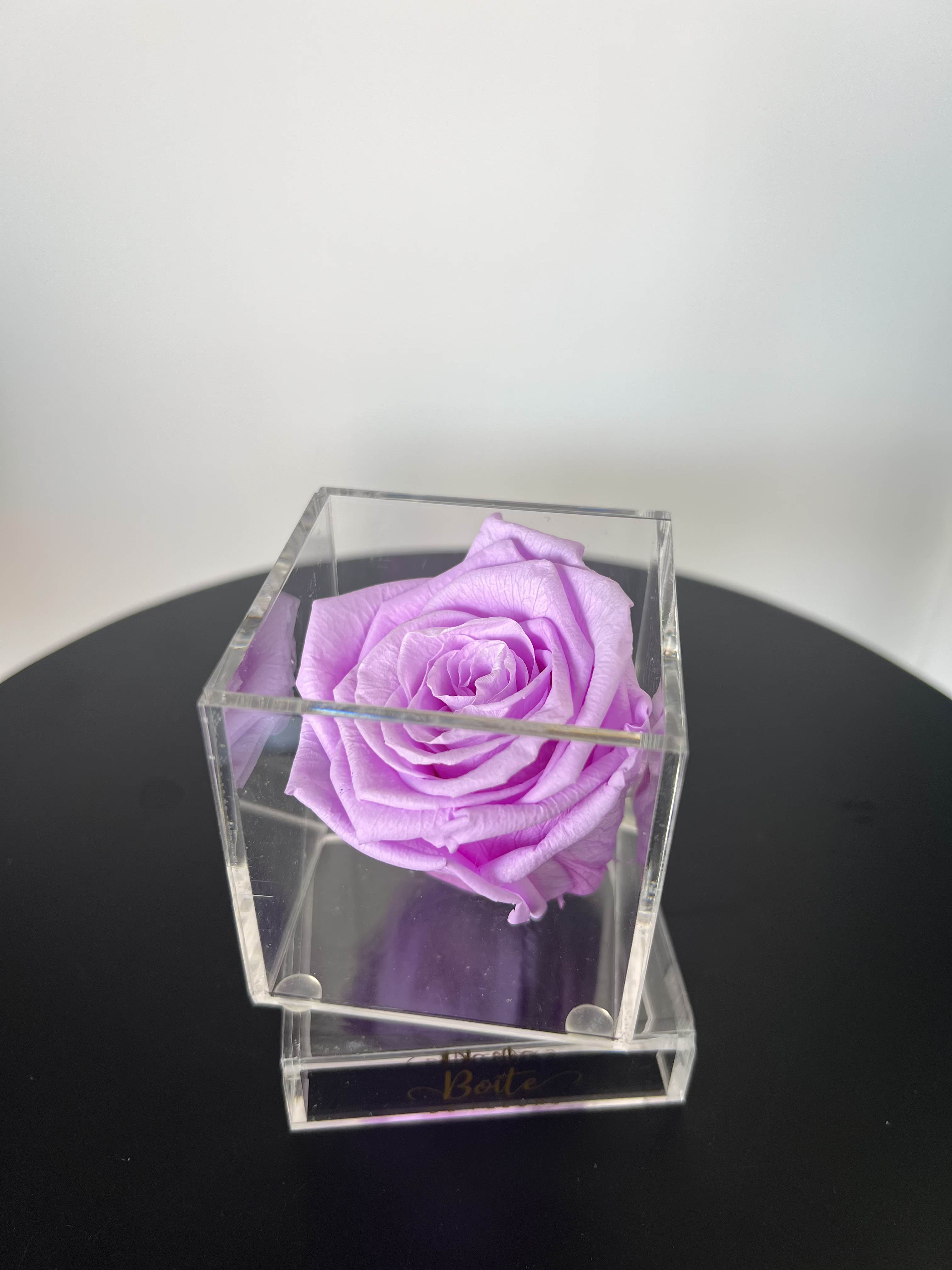 Petit Forever Boîte (Lavender) - A single forever rose sits in a custom acrylic box. This petit boîte is the perfect addition to your make up vanity, kitchen, bathroom counter, nightstand, or anywhere that needs a small beautiful rose decoration! Forever roses can last 3+ years with the proper love and care. 