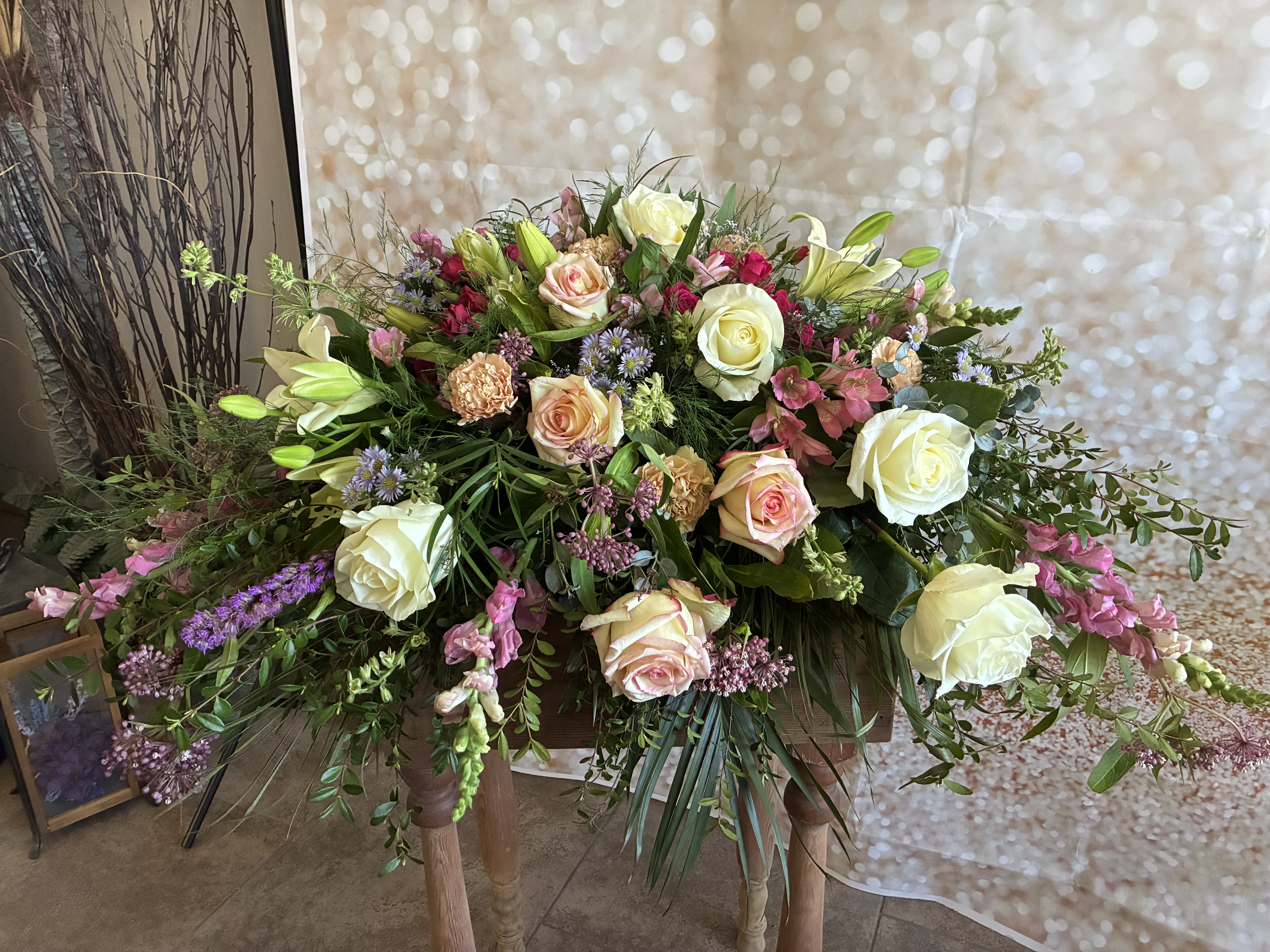 Large floral arrangement with cream and blush roses, lilies, and pink accents