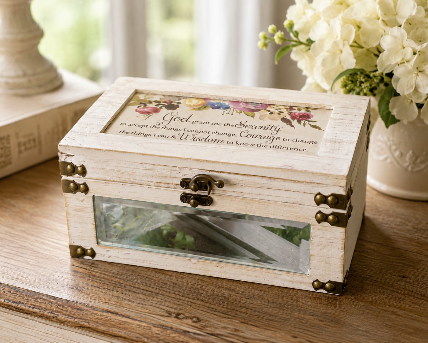 Serenity Prayer Musical Keepsake Box - Serenity Prayer Keepsake Music Box combines faith, inspiration, and timeless beauty in a meaningful decorative keepsake. Featuring the beloved Serenity Prayer on the lid, this elegant music box plays the beloved hymn How Great Thou Art, adding an extra layer of faith, comfort, and inspiration. Serving as a reminder of peace, courage, wisdom, and strength through life’s challenges and celebrations.  Designed with a rich wood finish, mirrored accents, and decorative hardware, this keepsake box provides a special place to store jewelry, notes, photographs, mementos, and treasured belongings. Its classic design complements a variety of decorating styles and looks beautiful displayed on a dresser, nightstand, bookshelf, desk, mantel, or prayer space.   The Serenity Prayer has offered encouragement and comfort to generations, making this music box a thoughtful choice for birthdays, encouragement, recovery journeys, church members, caregivers, teachers, friends, family, and anyone facing a season of change or uncertainty. It is equally appropriate as a faith-based gift, inspirational keepsake, thinking-of-you gift, recovery gift, or remembrance piece.  Each music box is accented with a coordinating ribbon selected to complement its design and presentation. Whether displayed in the home, office, or personal reflection space, it offers a lasting expression of faith, hope, grace, encouragement, support, and meaningful gift. 