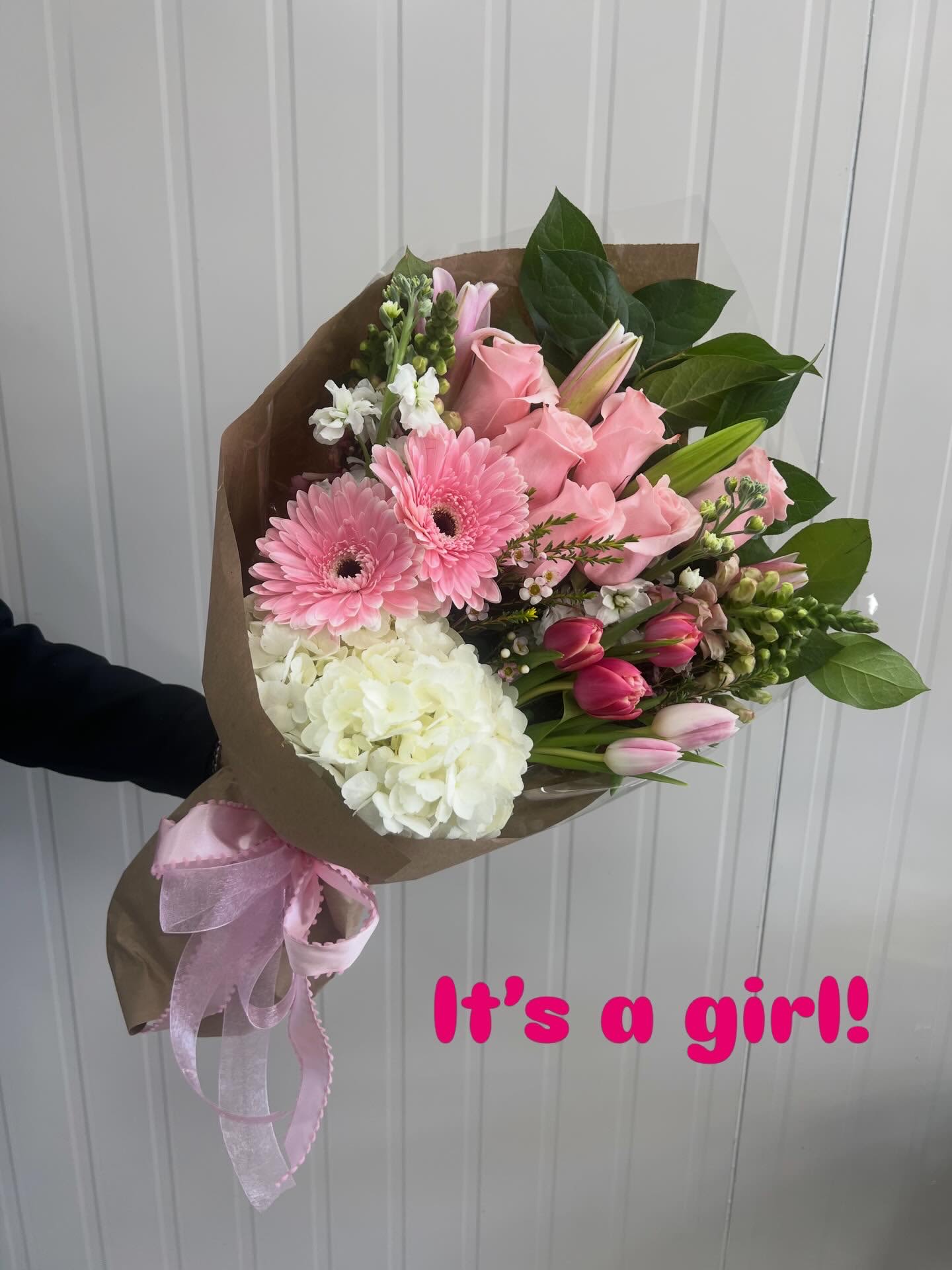 Wrap - It's a Girl - This is a Designers Choice Item filled to value. The designer will use the freshest most beautiful blooms to create a Pink and White flower wrap. 