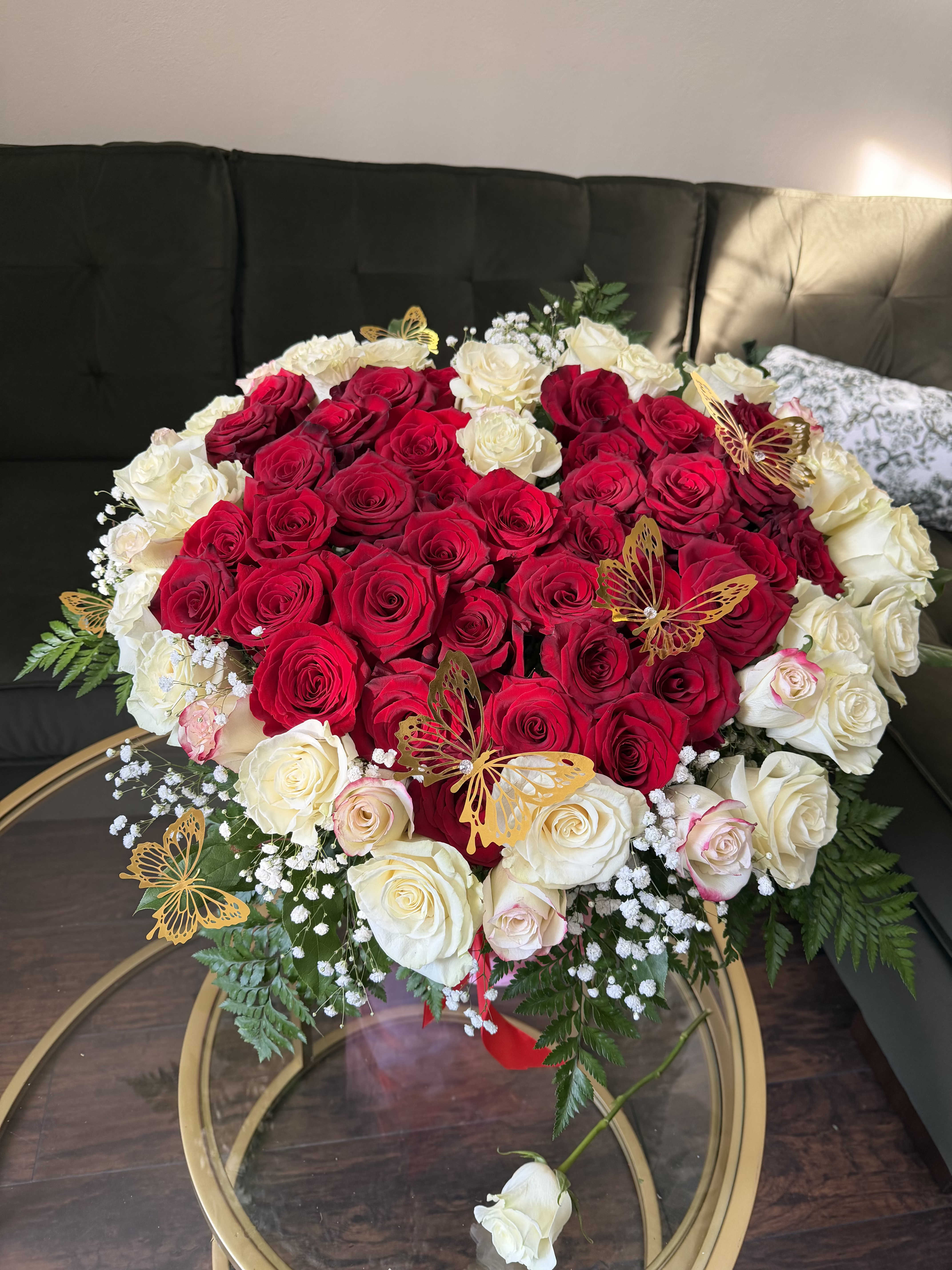 Heart-shaped bouquet of red and white roses with butterfly picks