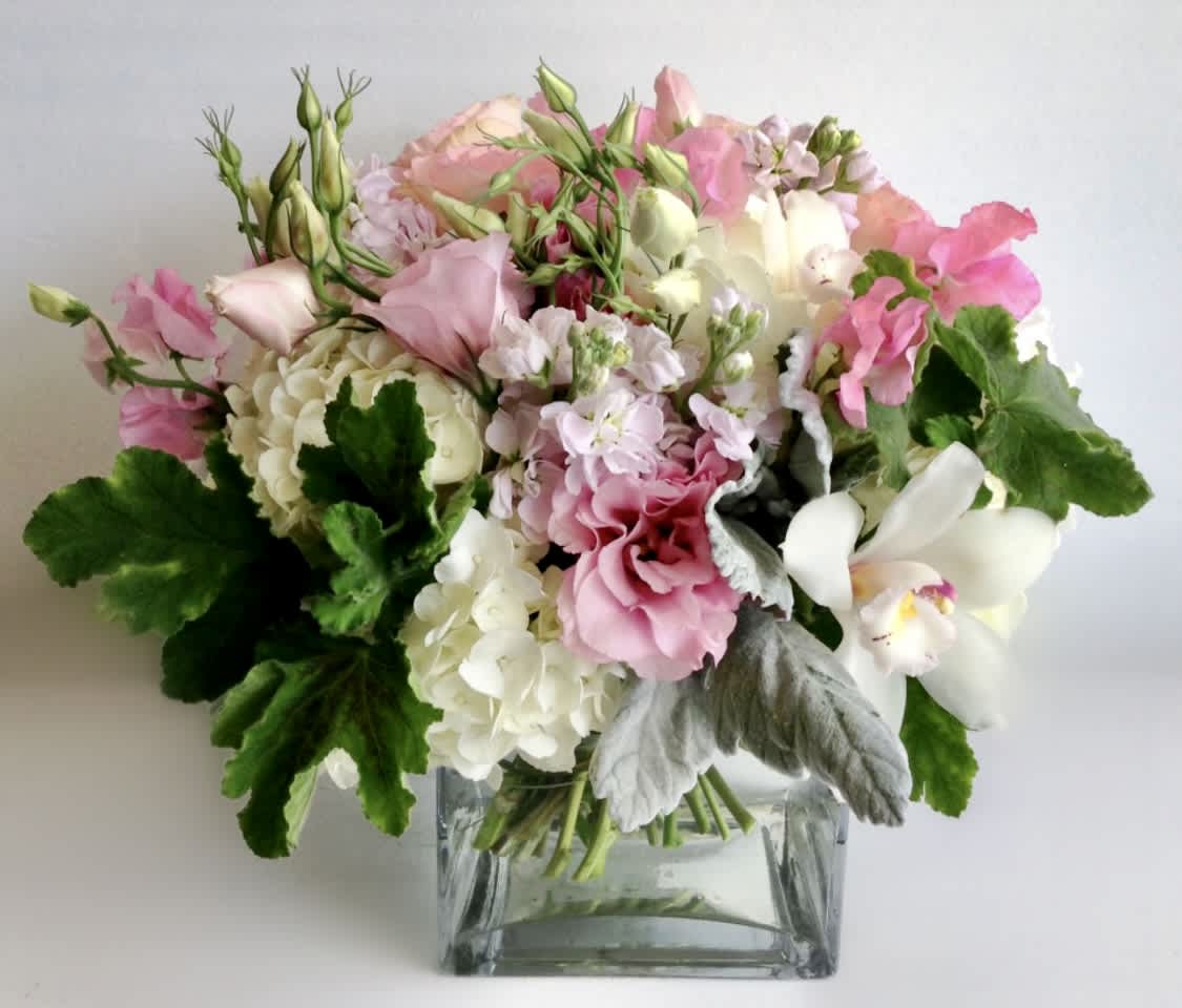 Pink and white mixed bouquet in a square glass vase