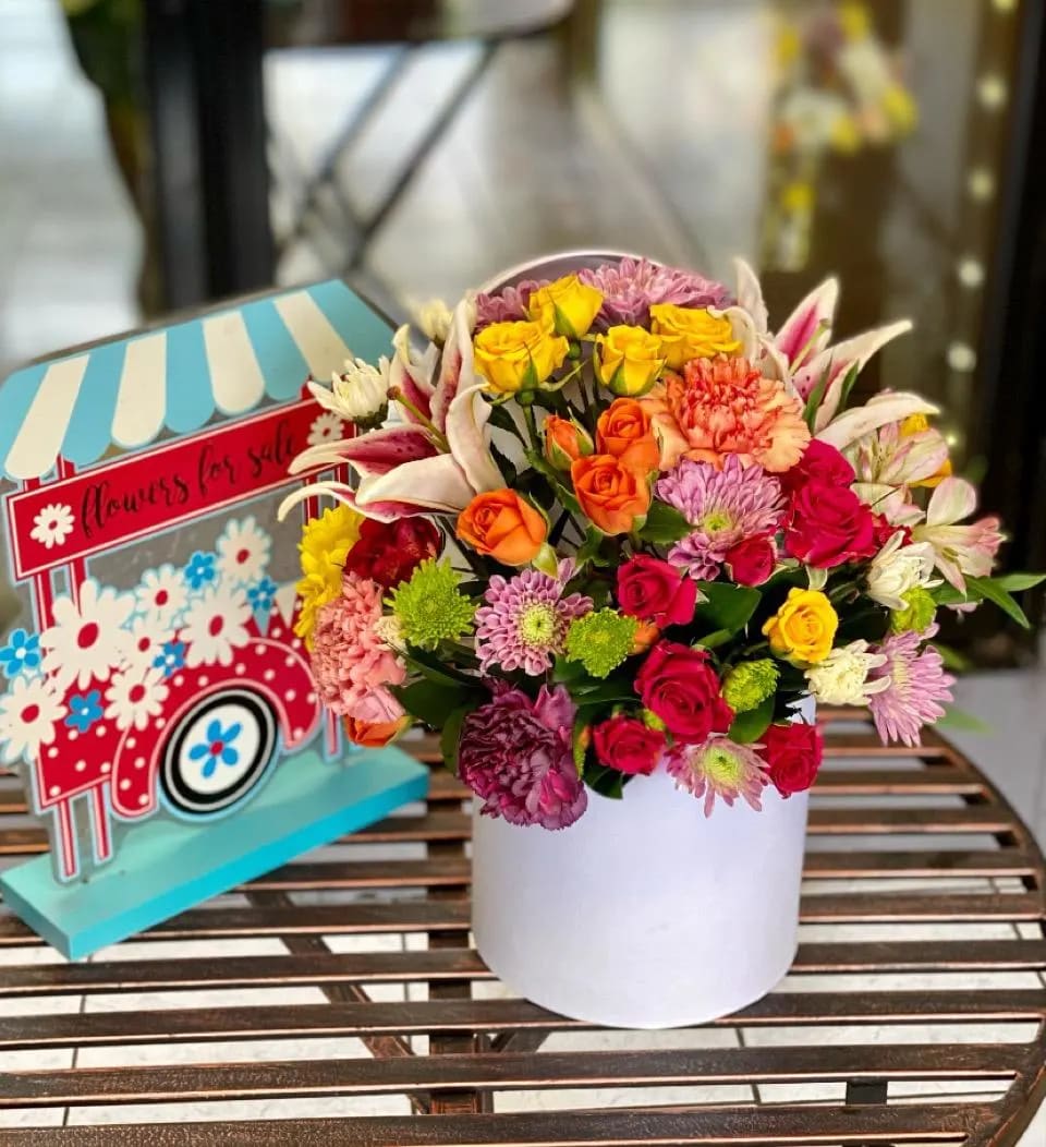 Colorful mixed bouquet in a white box with roses and lilies