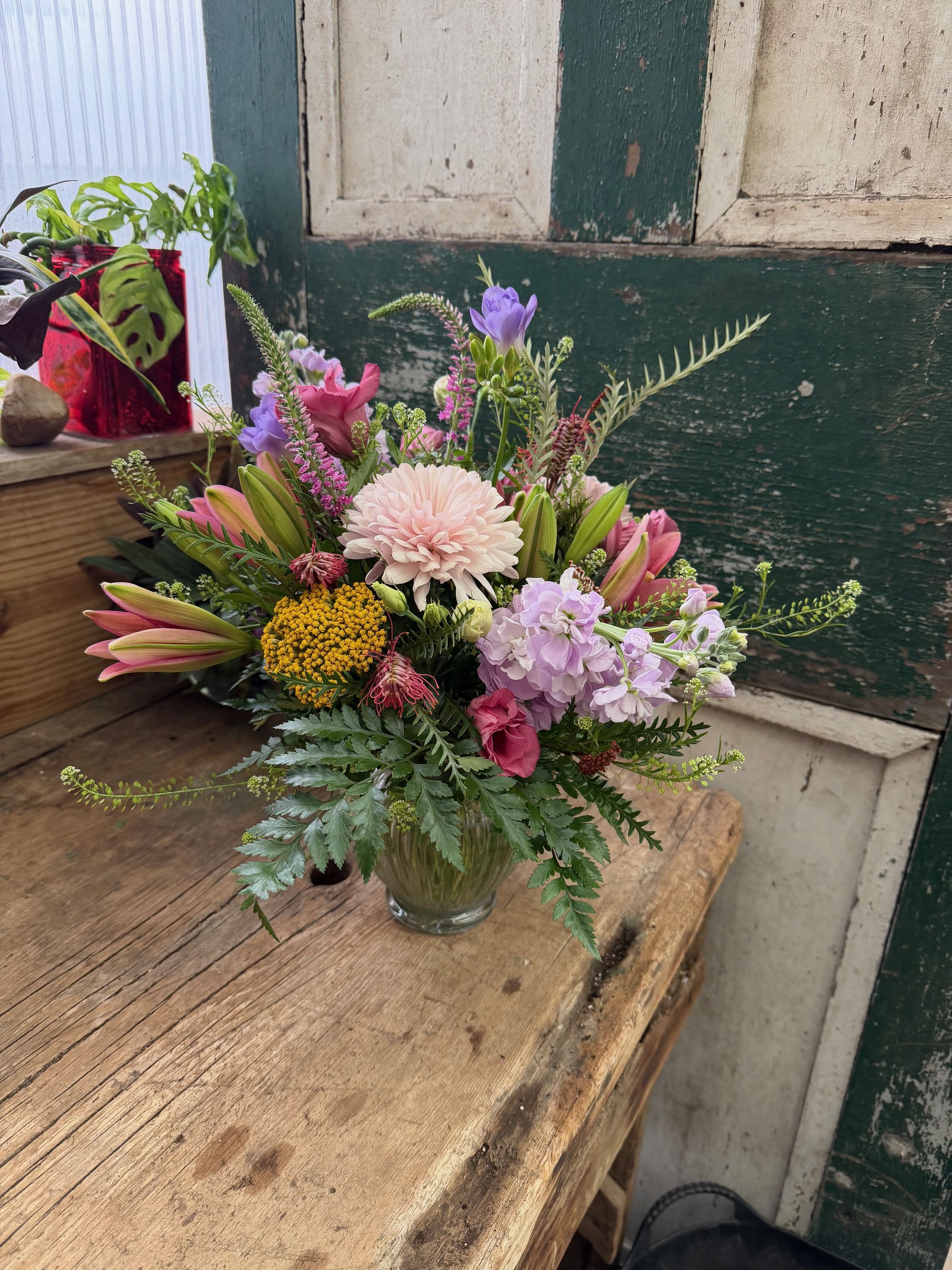 Mixed bouquet in a clear glass vase with pink, purple, and yellow blooms