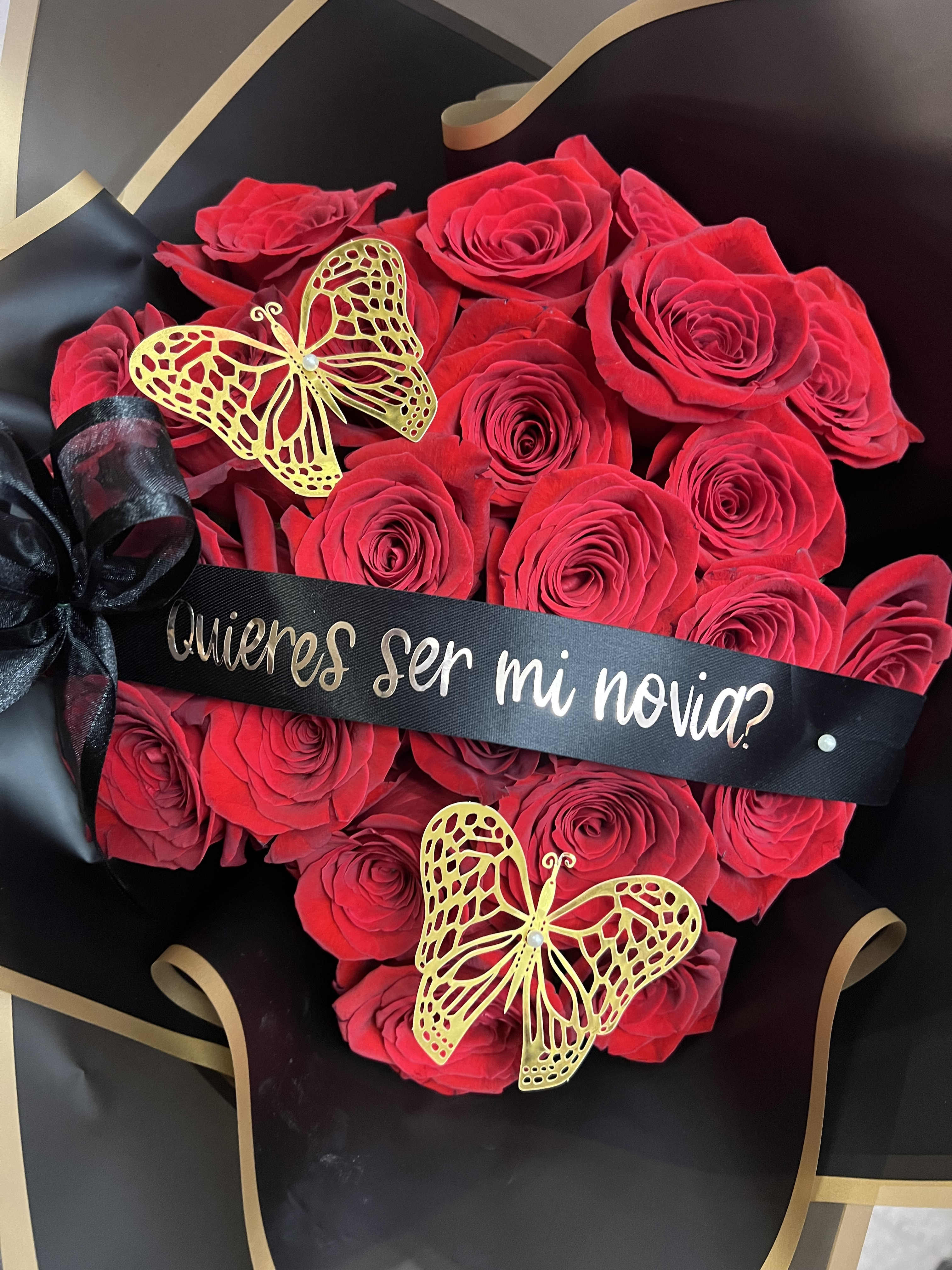 Red rose bouquet with black ribbon and gold butterfly decorations