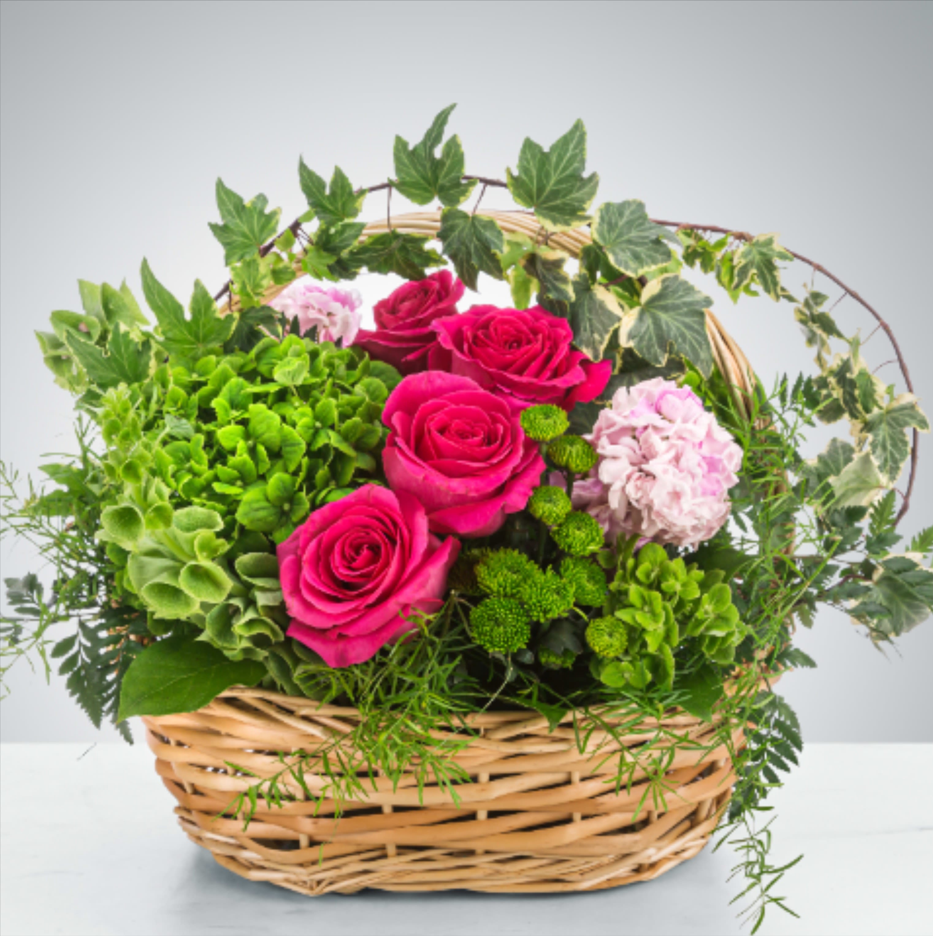 After the Rain by BloomNation™ - A green basket with a pop of hot pink roses, this arrangement can only be described as refreshing. Send it to say thank you and to show your appreciation!  Approximate Dimensions: 15"D x 12"H