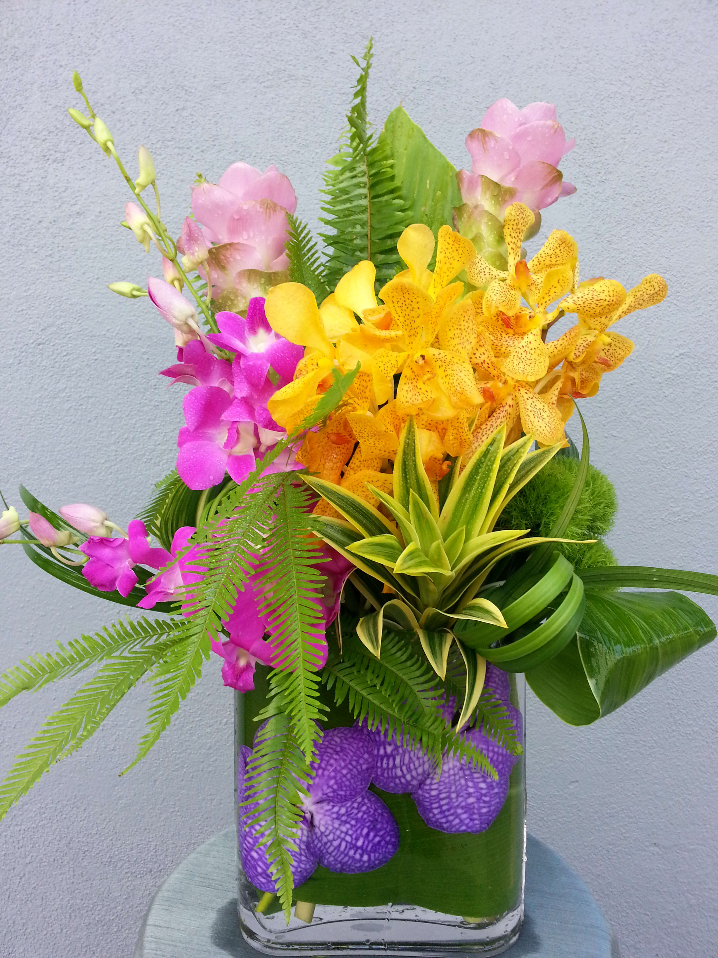 Colorful orchid arrangement in a glass vase