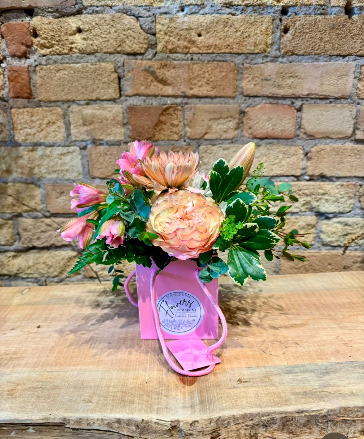 Pink and peach bouquet in a pink gift bag with rope handles