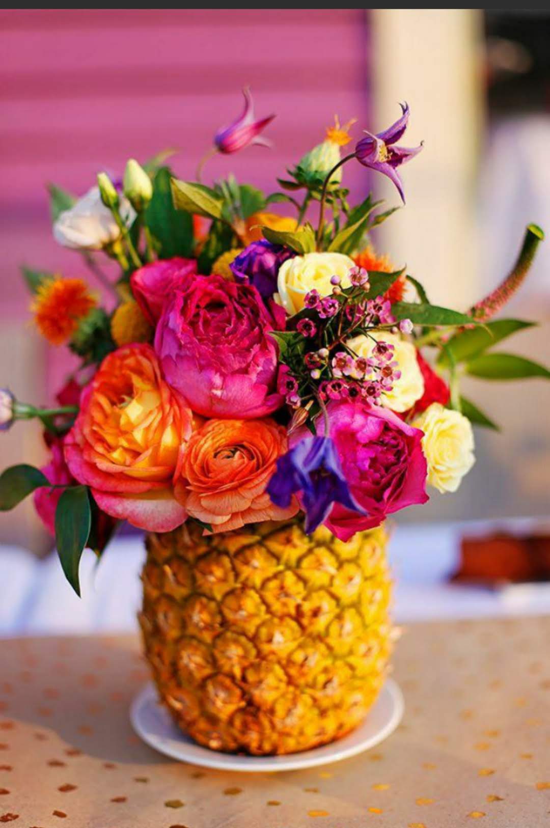 Tropical Sunset Pineapple - Playful, bold, and bursting with tropical energy, this vibrant floral arrangement is designed inside a real pineapple for a fun luxury island-inspired presentation. Featuring premium garden roses, ranunculus, lisianthus, wax flower, tropical accents, and vivid seasonal blooms in shades of hot pink, coral, orange, yellow, and purple, this artistic floral design creates an unforgettable statement piece. Perfect for birthdays, summer parties, celebrations, thank you gifts, tropical-themed events, or anyone who loves bright exotic flowers with a creative twist. The fresh pineapple container adds texture, fragrance, and tropical charm while the lush premium blooms bring rich color and modern floral artistry together in one unforgettable design. Professionally handcrafted by the experienced floral designers at Purple Orchid Flowers and available for flower delivery throughout the Omaha metro area.