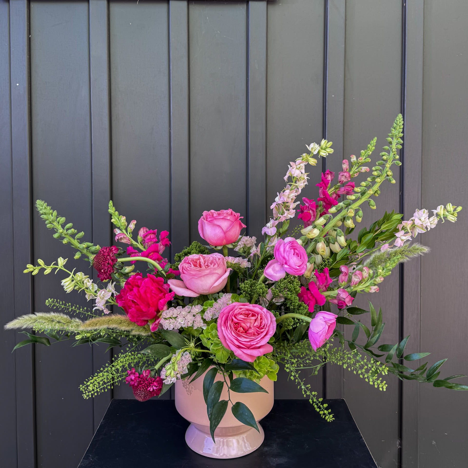 Watermelon Wave - These vibrantly hued blooms are a total show stopper in a complimentary peach ceramic vessel.  Upgrade to deluxe or premium for additional premium blooms.