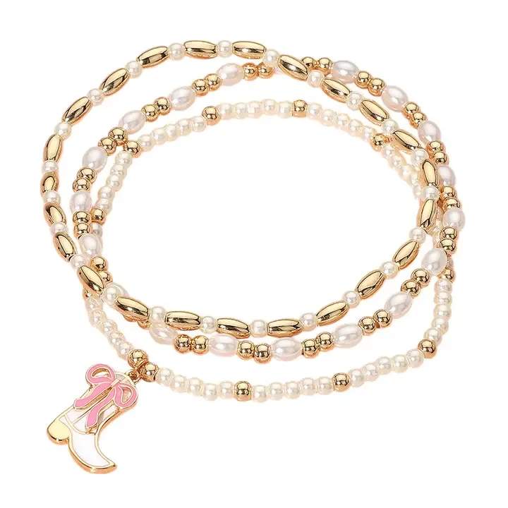 3PCS - Enamel Bow Cowboy Boot Pearl Beaded Multi Layered Bracelet - Size : 1.2" H Stretchable Add a playful western flair to your look with this gold and faux pearl beaded wrap bracelet, featuring a enamel cowboy boot charm. Stretchy and stylish, it wraps elegantly around your wrist for a trendy layered effect. Perfect for cowgirl chic outfits and country lovers. Lead and Nickel Compliant Brass