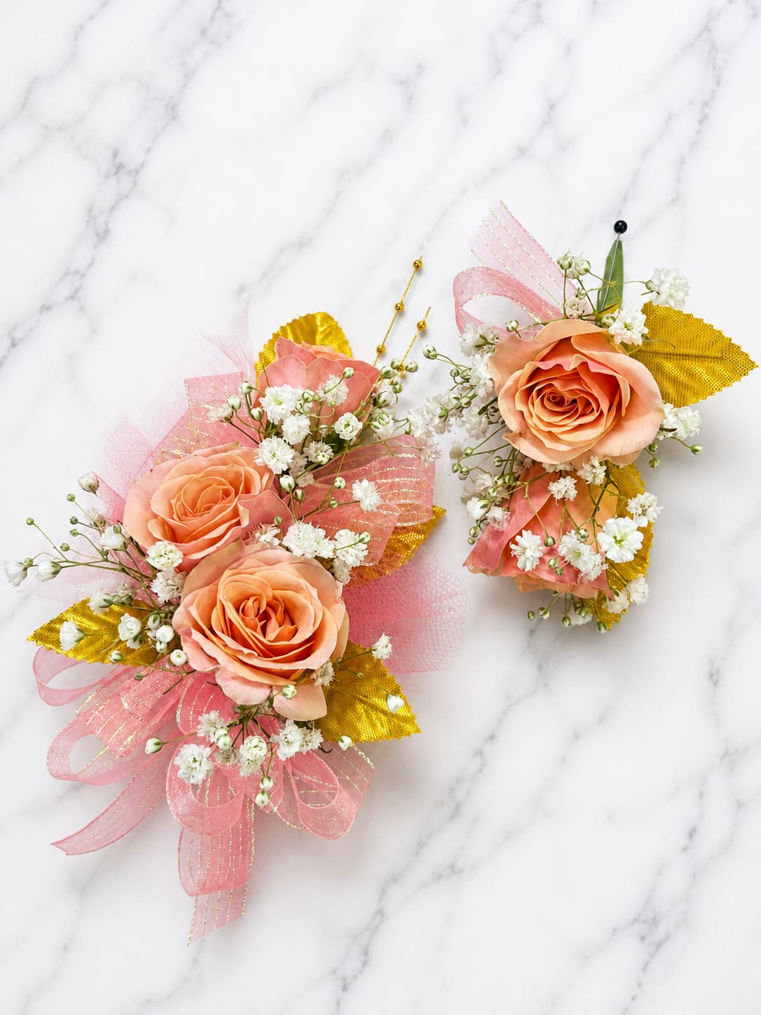 Coral Sunset Formal Set - ️ MAGNETIC BOUTONNIERE WARNING: CONTAINS STRONG MAGNETS. DO NOT USE IF YOU HAVE A PACEMAKER, DEFIBRILLATOR, INSULIN PUMP, COCHLEAR IMPLANT, NEUROSTIMULATOR, OR OTHER IMPLANTED MEDICAL DEVICE. KEEP AWAY FROM ELECTRONICS, CREDIT CARDS, HOTEL KEY CARDS, AND CHILDREN.  Coral Sunset  Coral Sunset blends coral roses, soft peach tones, gold accents, and delicate white filler flowers into a bright, romantic corsage and boutonniere collection. Inspired by the colors of a summer sunset, this design is perfect for prom, homecoming, formal dances, banquets, weddings, and special occasions.  Standard includes a wrist corsage with 3 spray roses and a matching magnetic boutonniere with 2 roses. Deluxe includes 4 spray roses in the corsage. Premium includes 5 spray roses for additional flower coverage and visual impact. All boutonnieres include 2 roses.  Ideal for prom flowers, wrist corsages, magnetic boutonnieres, corsage and boutonniere sets, homecoming flowers, and formal event flowers.  Because each corsage and boutonniere is individually designed, no two sets will be exactly alike. Ribbon, filler flowers, bracelets, and decorative accents may vary based on availability. While individual details may differ, the overall color palette, flower count, style, and appearance of the Coral Sunset collection will be maintained.