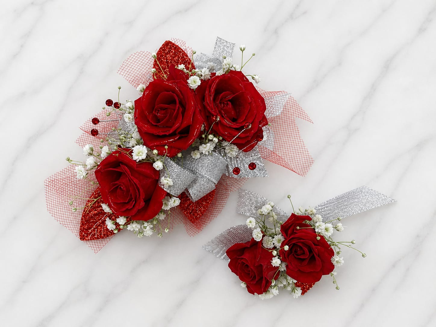 Scarlett Shimmer Formal Set - MAGNETIC BOUTONNIERE WARNING: CONTAINS STRONG MAGNETS. DO NOT USE IF YOU HAVE A PACEMAKER, DEFIBRILLATOR, INSULIN PUMP, COCHLEAR IMPLANT, NEUROSTIMULATOR, OR OTHER IMPLANTED MEDICAL DEVICE. KEEP AWAY FROM ELECTRONICS, CREDIT CARDS, HOTEL KEY CARDS, AND CHILDREN.  Scarlet Shimmer  Vibrant red roses, sparkling silver accents, shimmering ribbon, and delicate filler flowers come together in Scarlet Shimmer, a bold corsage and boutonniere collection designed for prom, homecoming, dances, banquets, weddings, and formal events. The striking combination of rich scarlet blooms and silver sparkle creates a dramatic look that stands out beautifully in photographs while maintaining timeless elegance.  Standard includes a wrist corsage with 3 spray roses and a matching magnetic boutonniere with 2 roses. Deluxe includes 4 spray roses in the corsage. Premium includes 5 spray roses for additional fullness and flower coverage. All boutonnieres include 2 roses.  Perfect for prom flowers, wrist corsages, magnetic boutonnieres, corsage and boutonniere sets, homecoming flowers, dance flowers, and formal event flowers.  Because each corsage and boutonniere is individually designed, no two sets will be exactly alike. Ribbon, filler flowers, bracelets, decorative accents, and other design elements may vary based on availability. While individual details may differ, the overall color palette, roses and/or flowers, style, and appearance of the Scarlet Shimmer collection will be maintained.