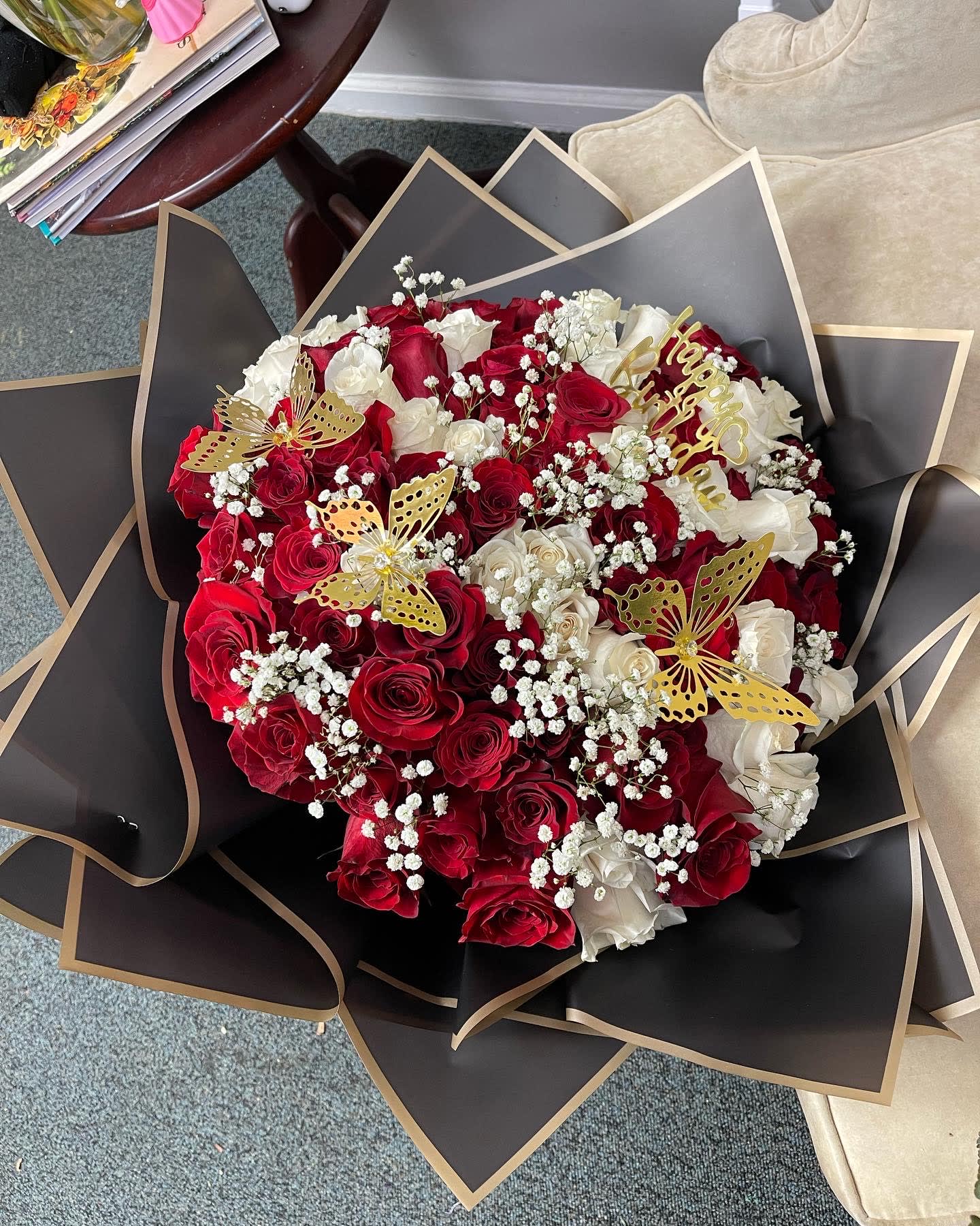 Bouquet of red and white roses with gold butterfly accents