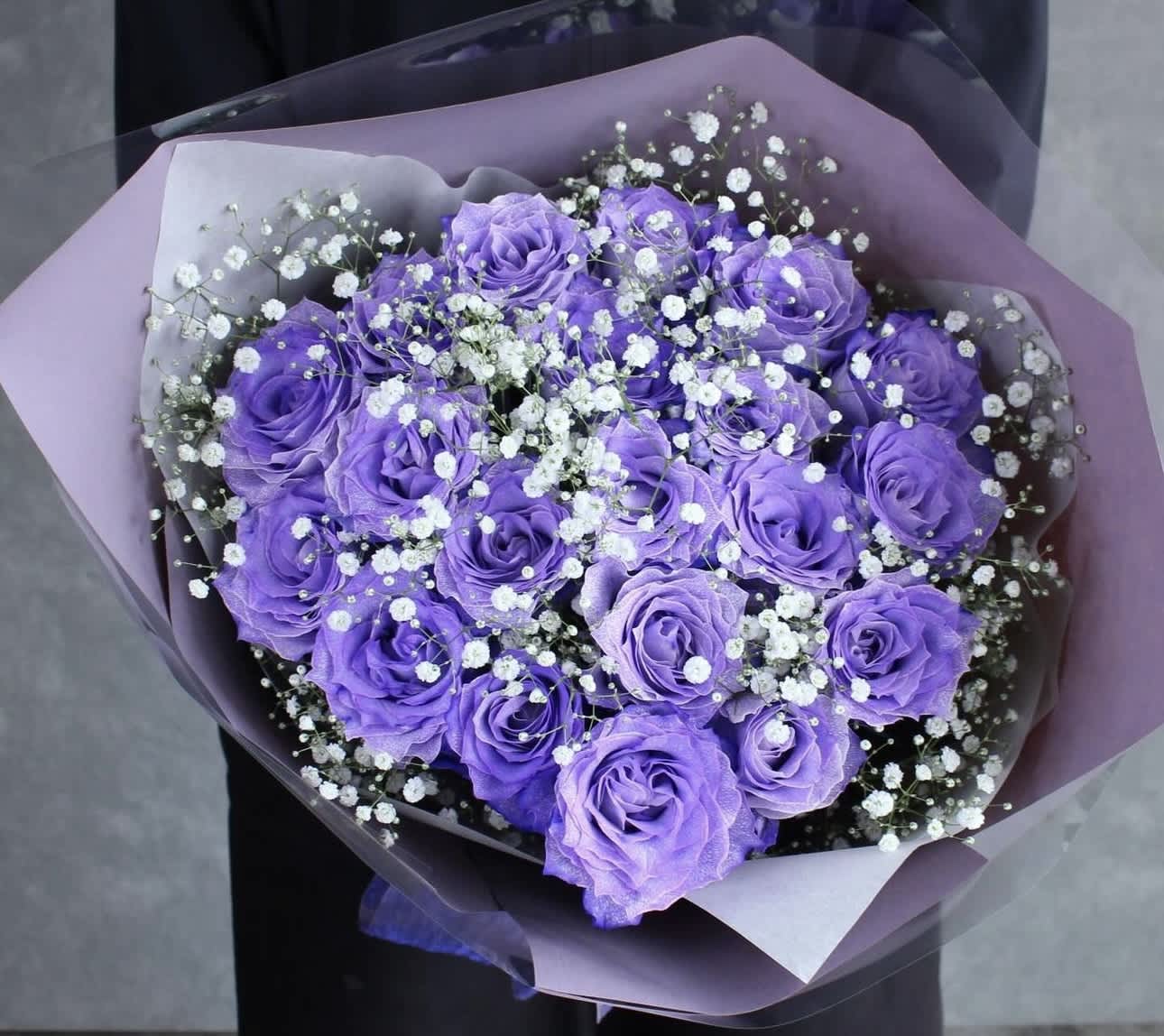 Bouquet of purple roses with white baby's breath in lavender wrap