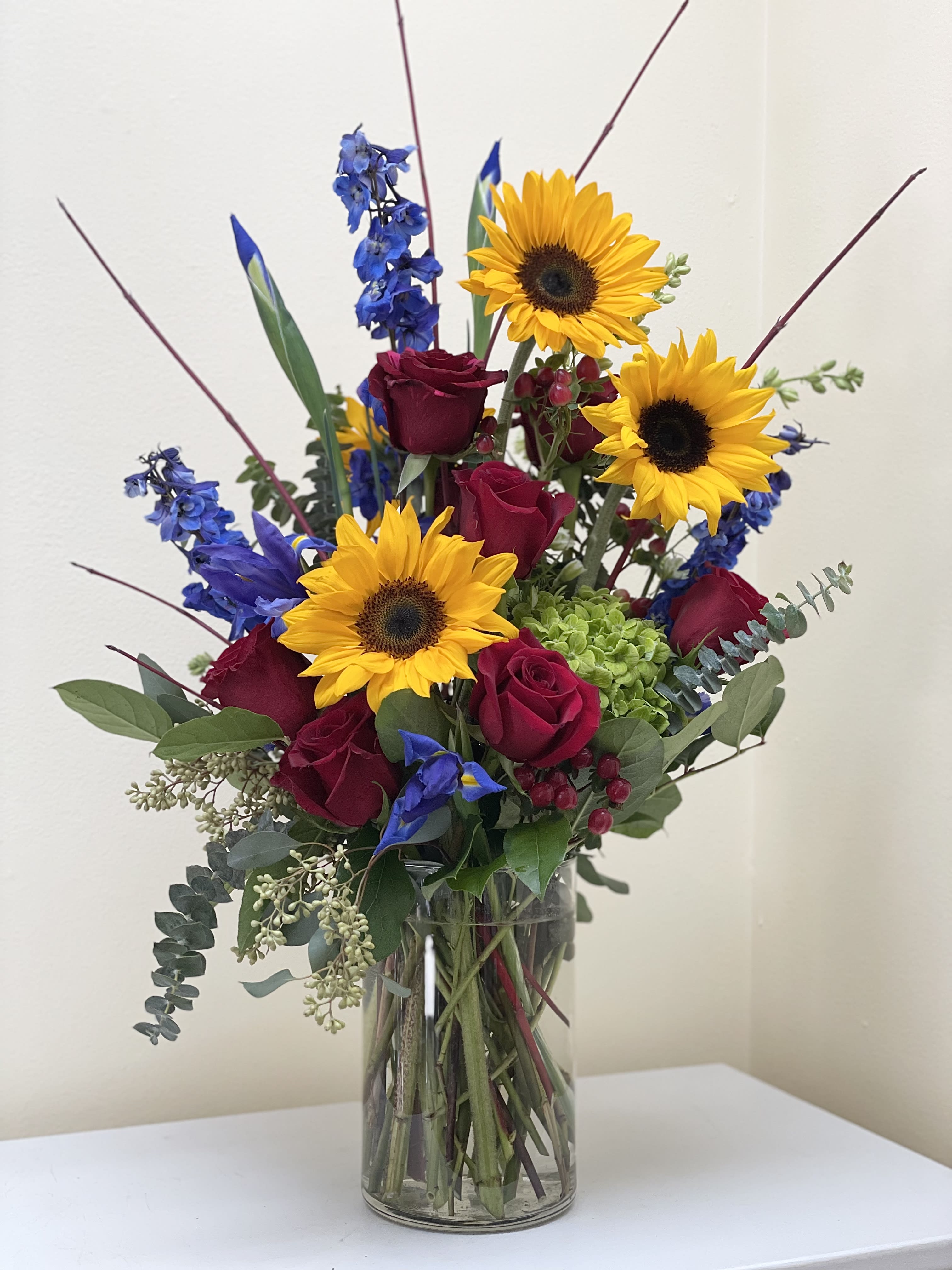Cheerful - A custom designed arrangement, bright and beautiful design, includes cheerful seasonal blooms surrounded by a variety of greens.