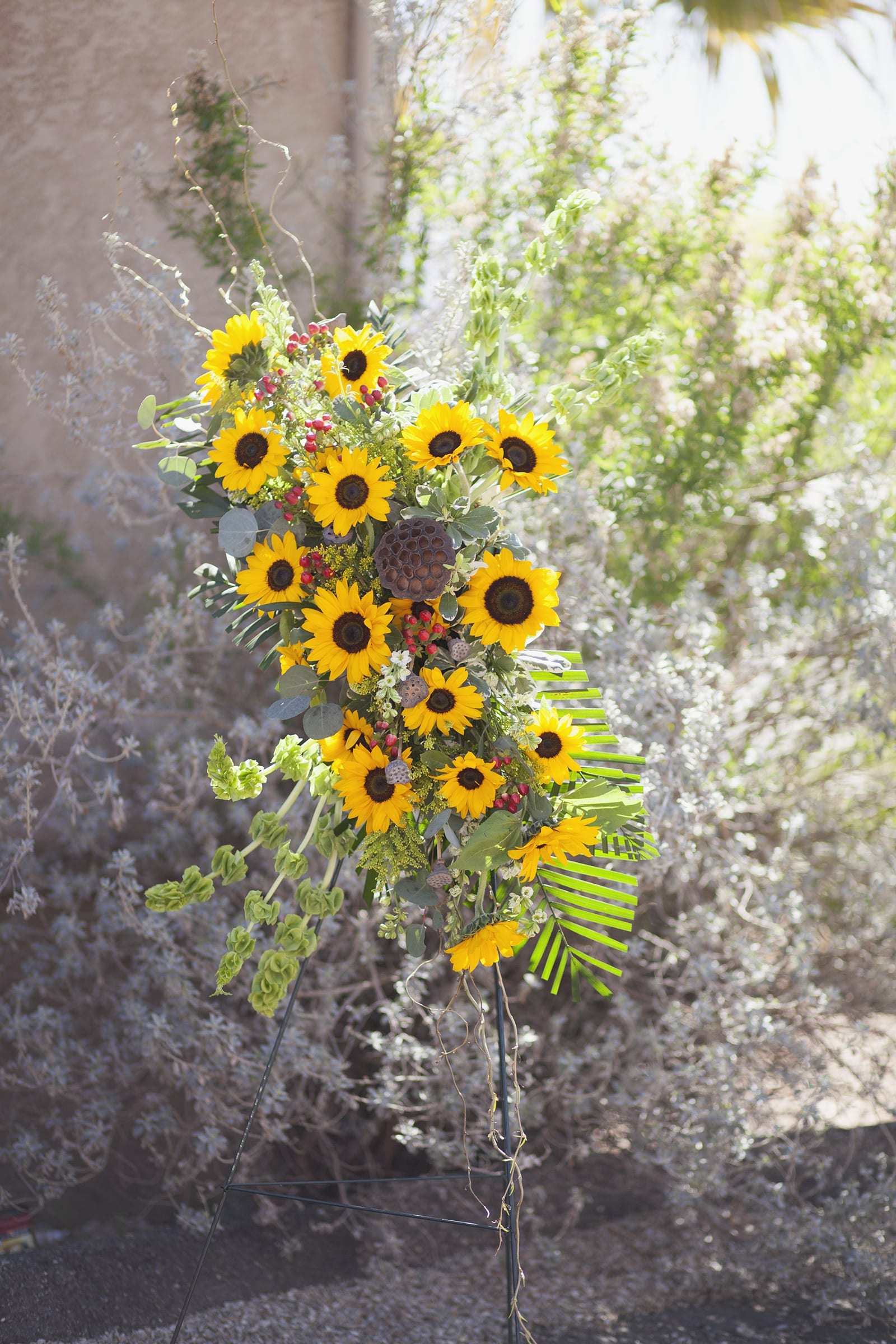 Tall sunflower arrangement with mixed greenery and red berry accents