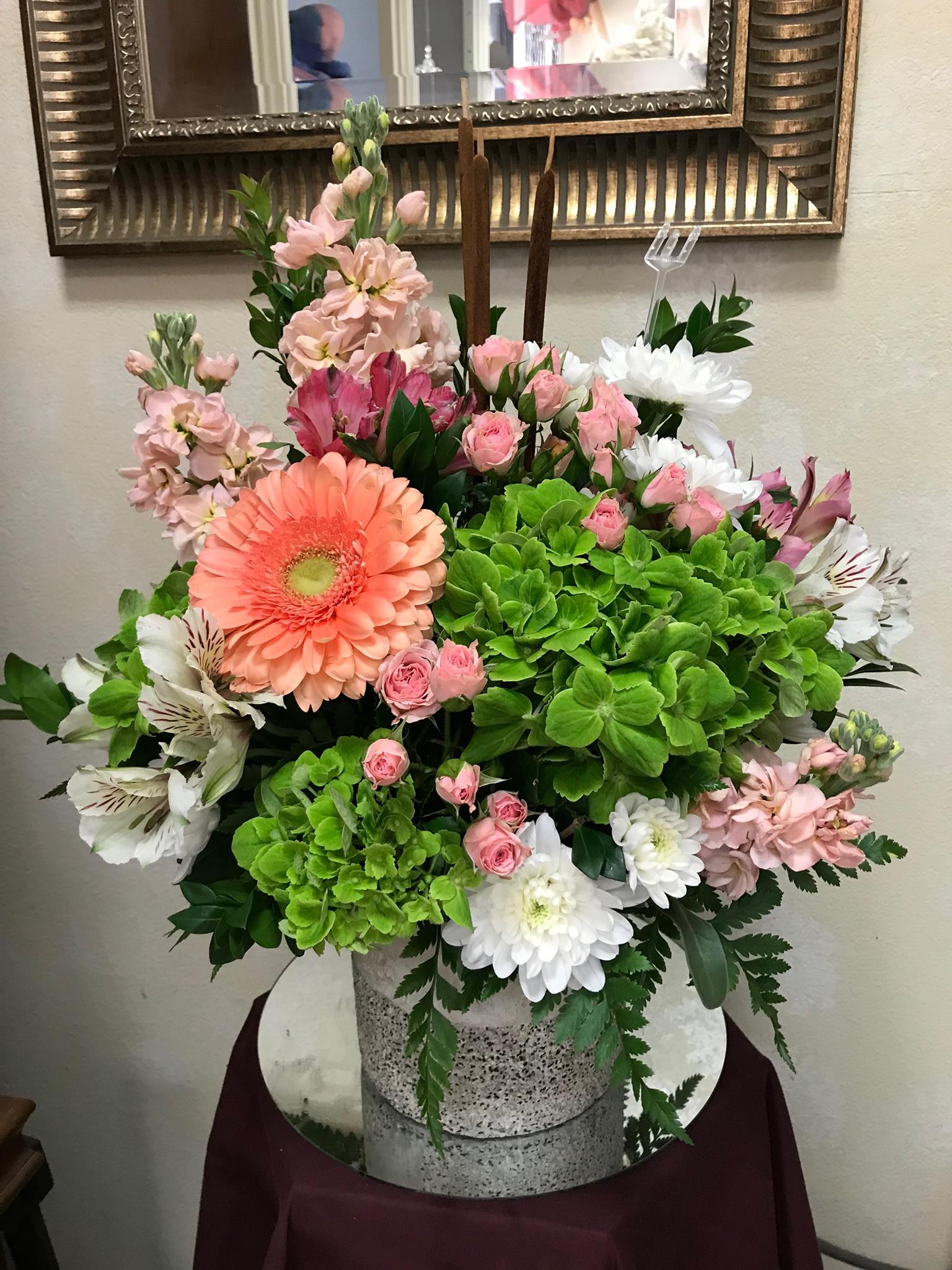Mixed pink, white, and green floral arrangement in a speckled container