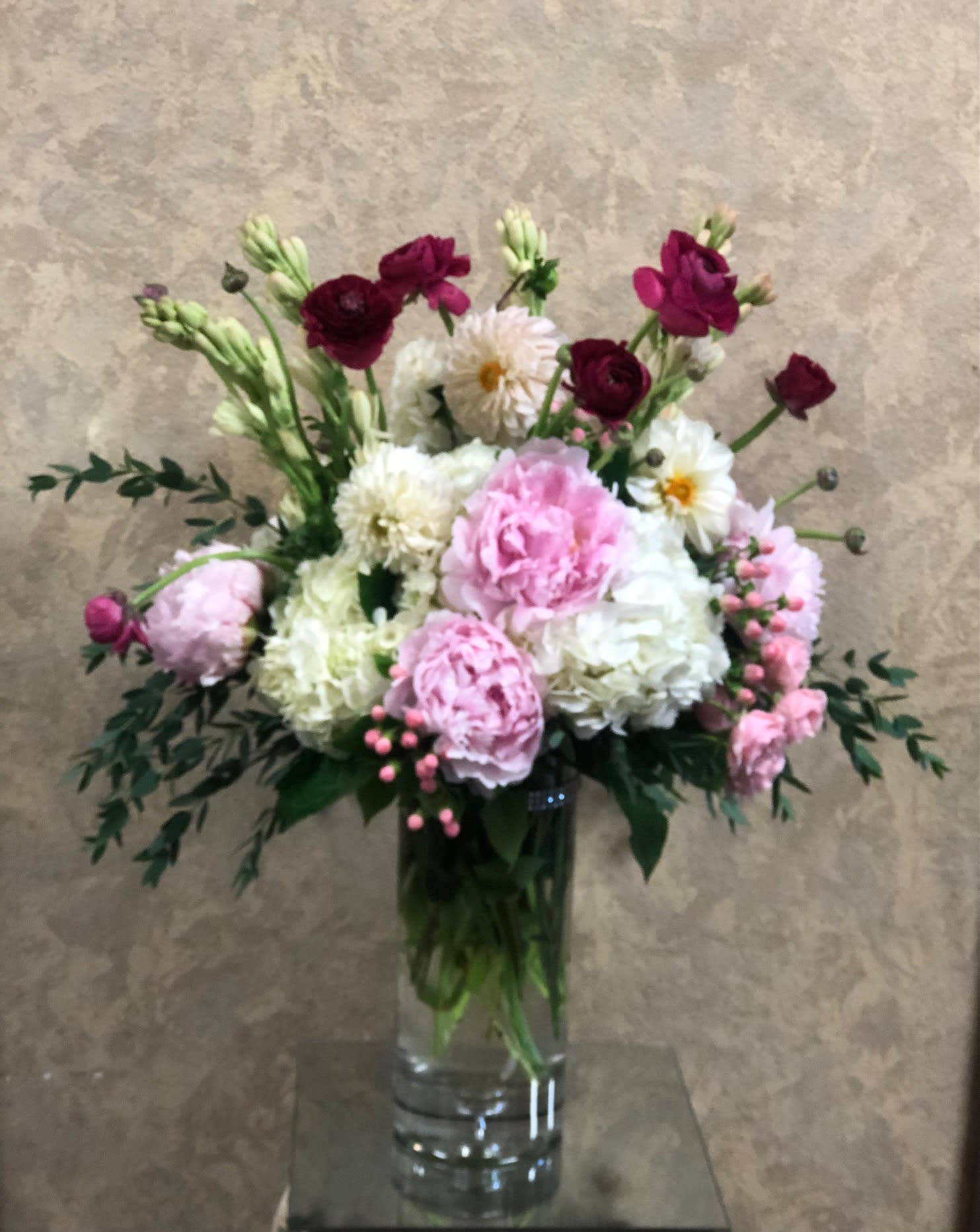 Diamond in the Sky - Send this extravagant piece to a special someone that says I love you!   Recipe: Peonies, Ranunculus, Dahlias, Hydrangeas, Spray Roses Hypericum Berries, and mroe in a tall clear vase. Availability: Seasonal Peonies, Dahlias, Ranunculus Design View: Symmetric Front Facing View Photo shown: Standard 
