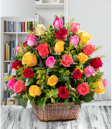 Basket of multicolored roses with yellow filler flowers