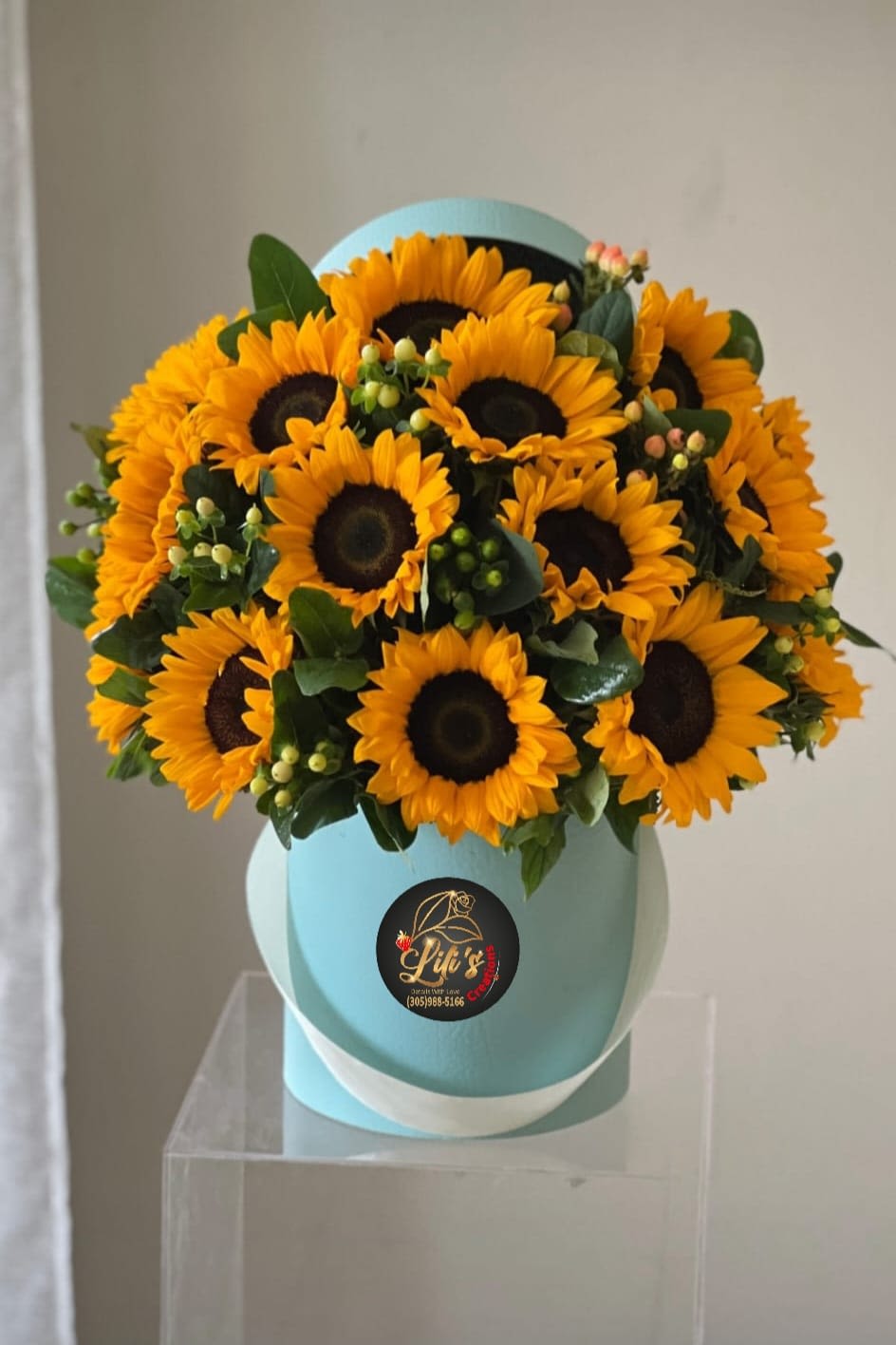 Bouquet of yellow sunflowers in a light blue hat box