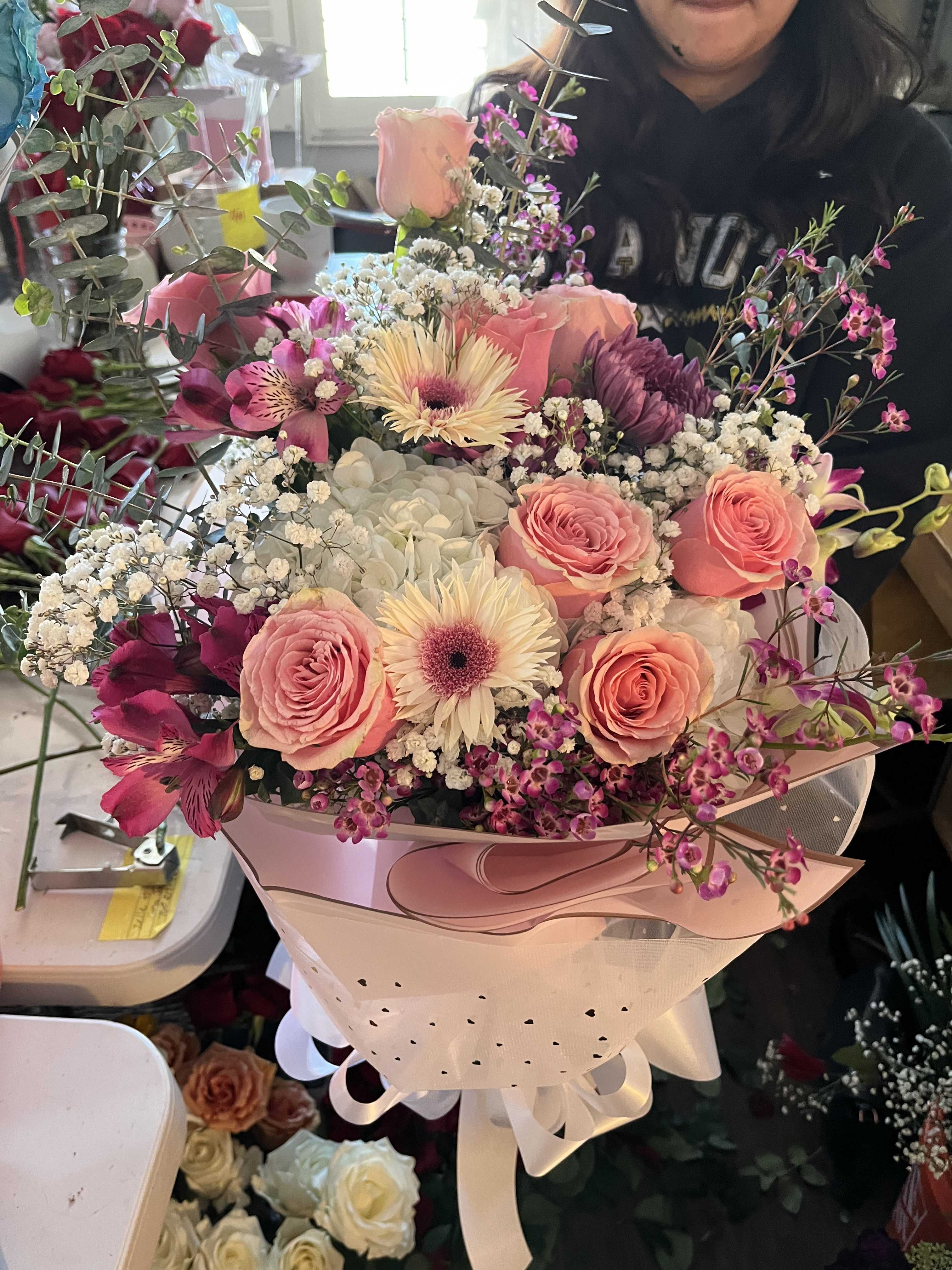 Pink and white mixed bouquet wrapped in pale paper with ribbon