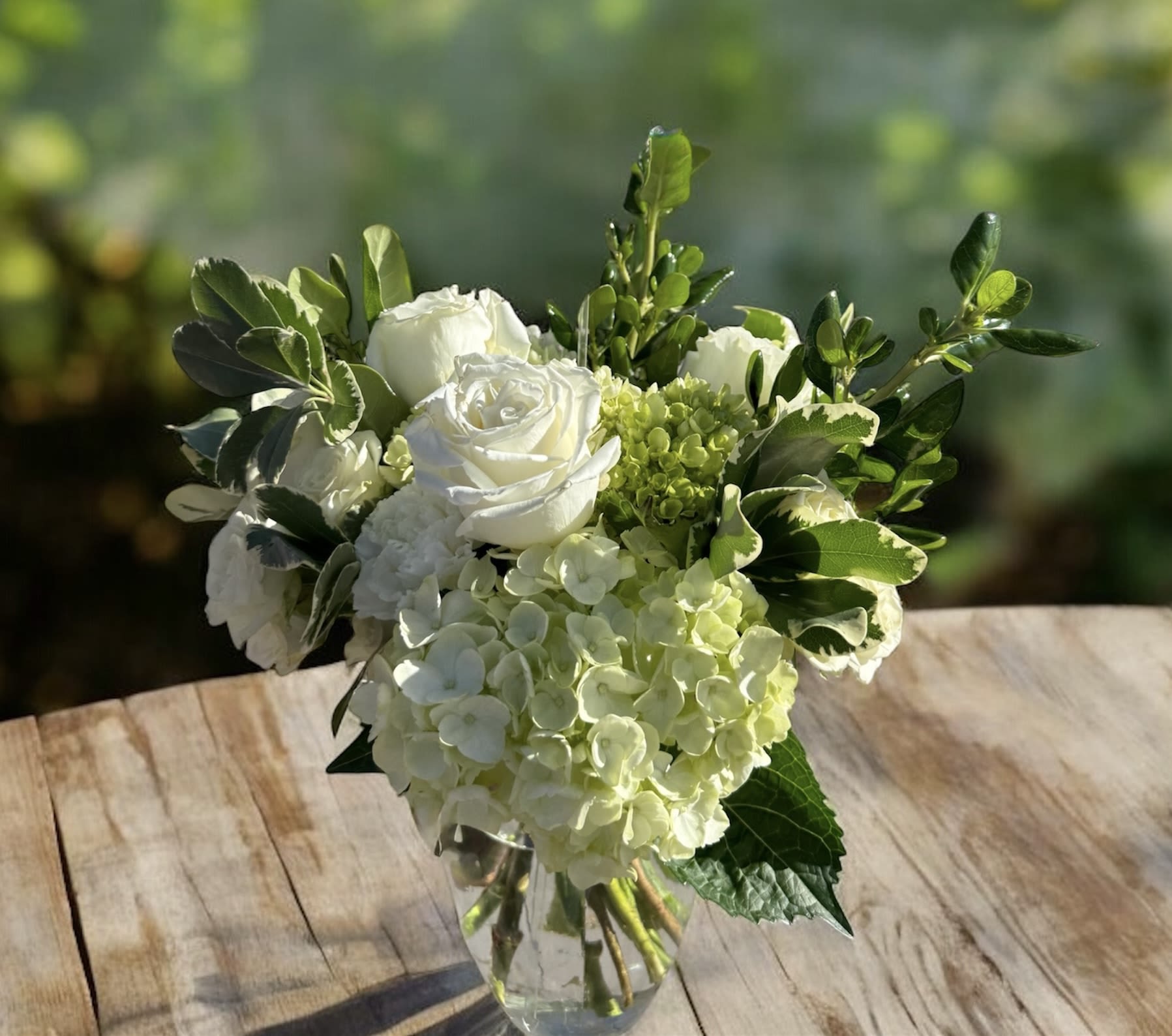 Mojito  - Steal the show with our Mojito arrangement! Bursting with fresh greens, creamy roses, cheerful green hydrangea, and whimsical berry accents, this design is full of vacation vibes.  Perfect for the one wanting something fresh and light. This joyful green-and-cream arrangement brings a fresh twist to anyone’s day. Fun and guaranteed to make the mind wander to a memories of a much needed beach vacation. 